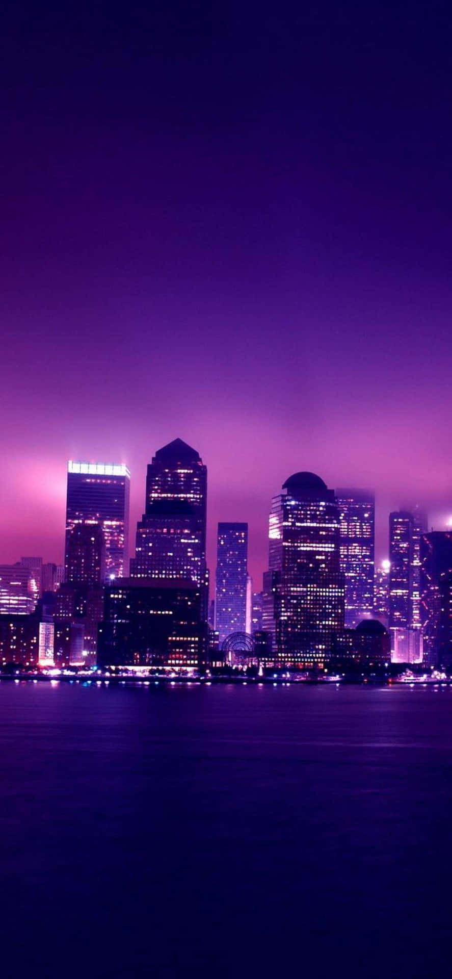 A Purple Skyline With Buildings And Lights Wallpaper