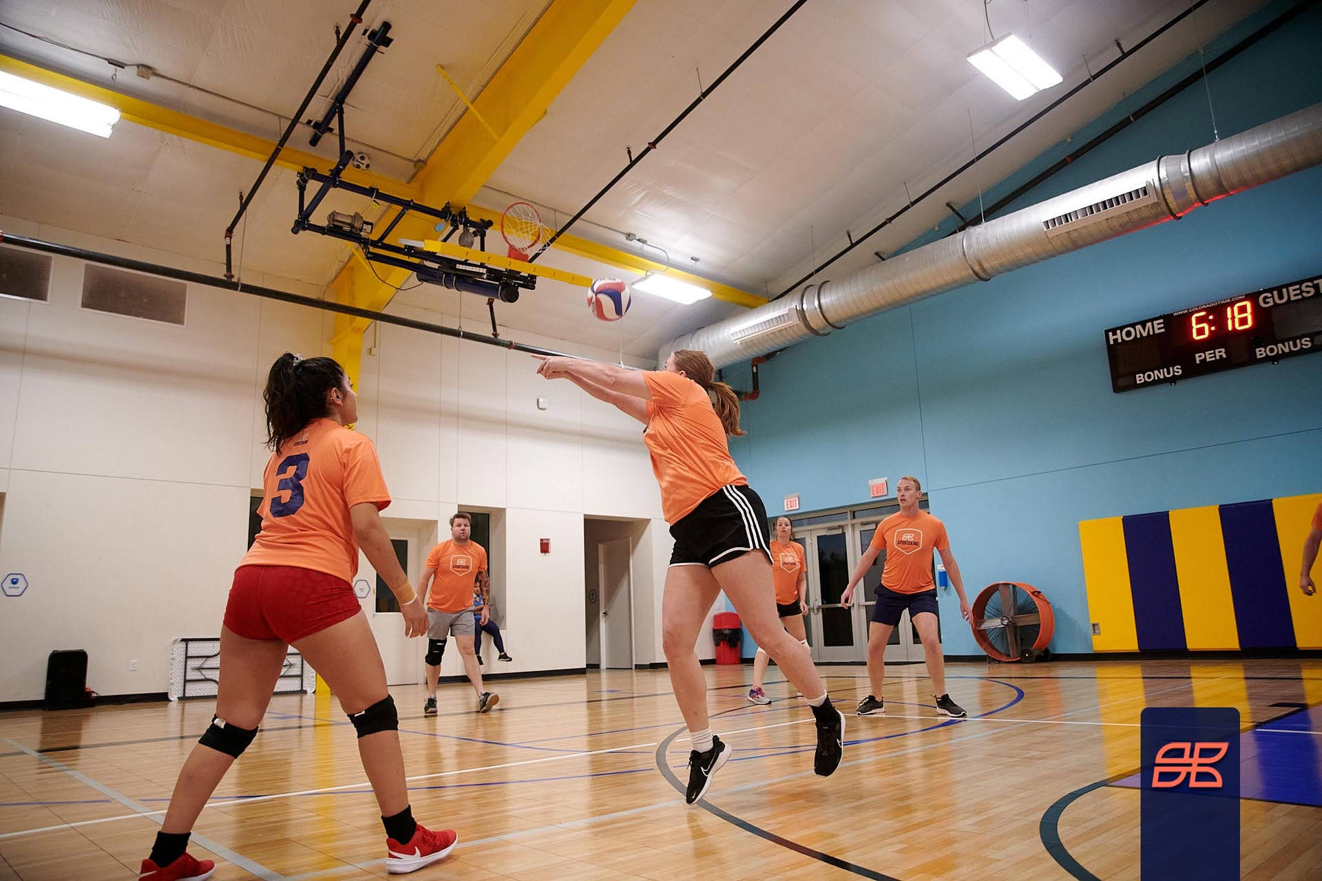 En gruppe piger der spiller volleyball i et gymnasium Wallpaper