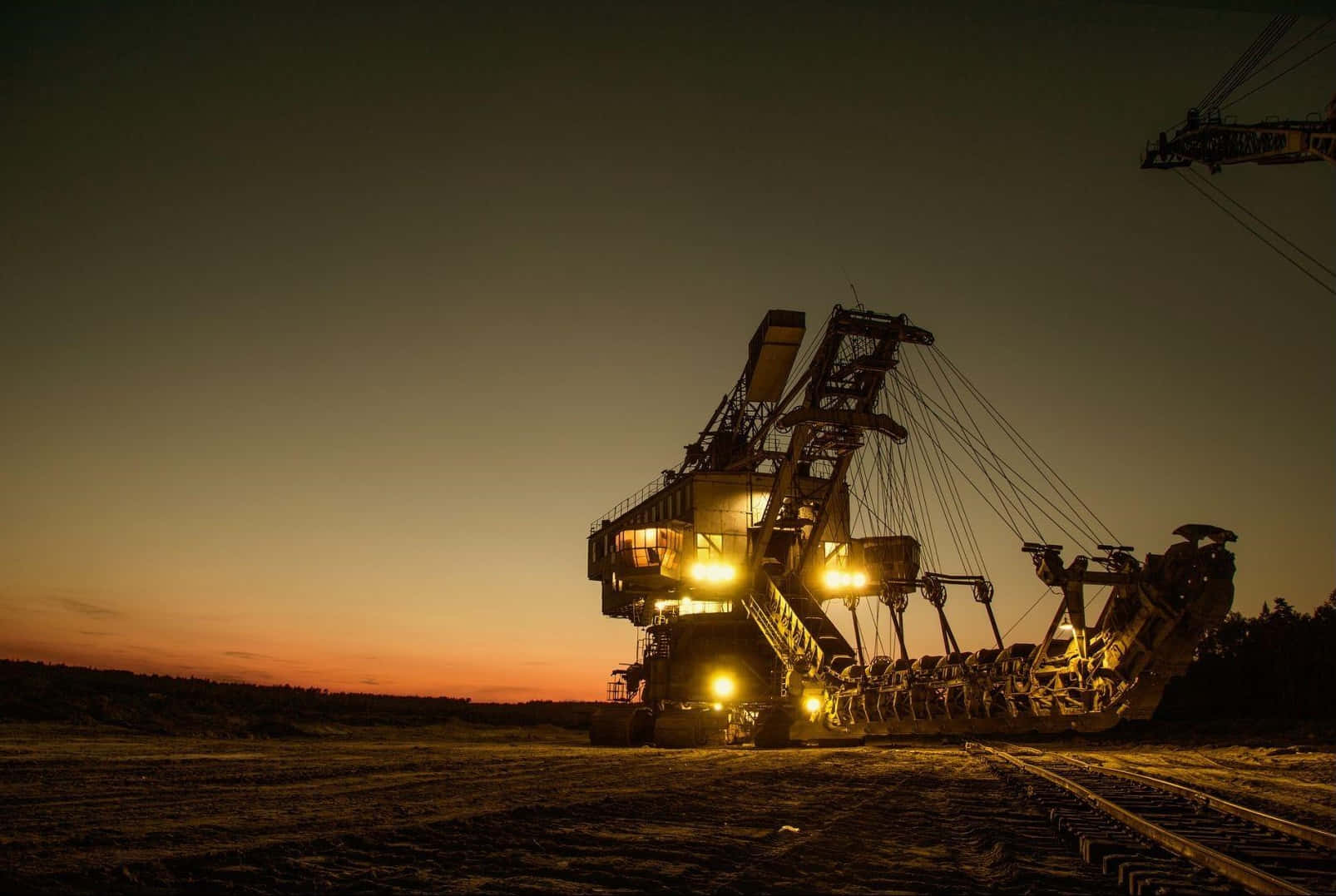 A Large Crane Is Sitting In The Middle Of A Field At Night