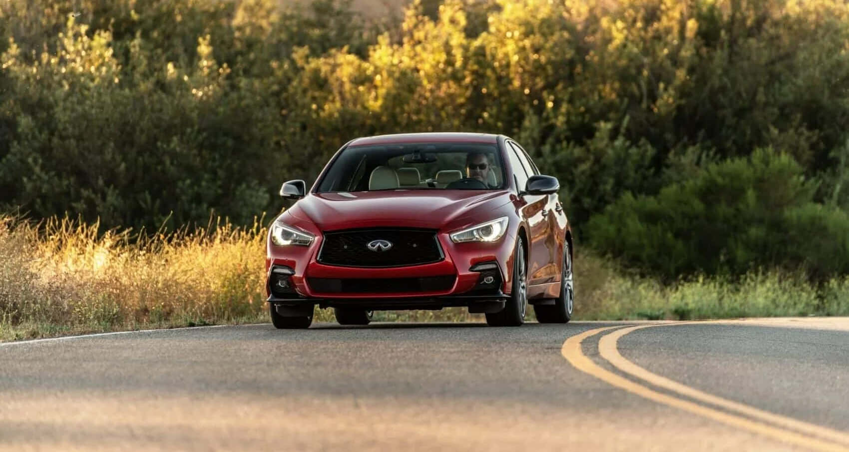 The Red 2019 Infiniti Qx50 Driving Down A Country Road Wallpaper