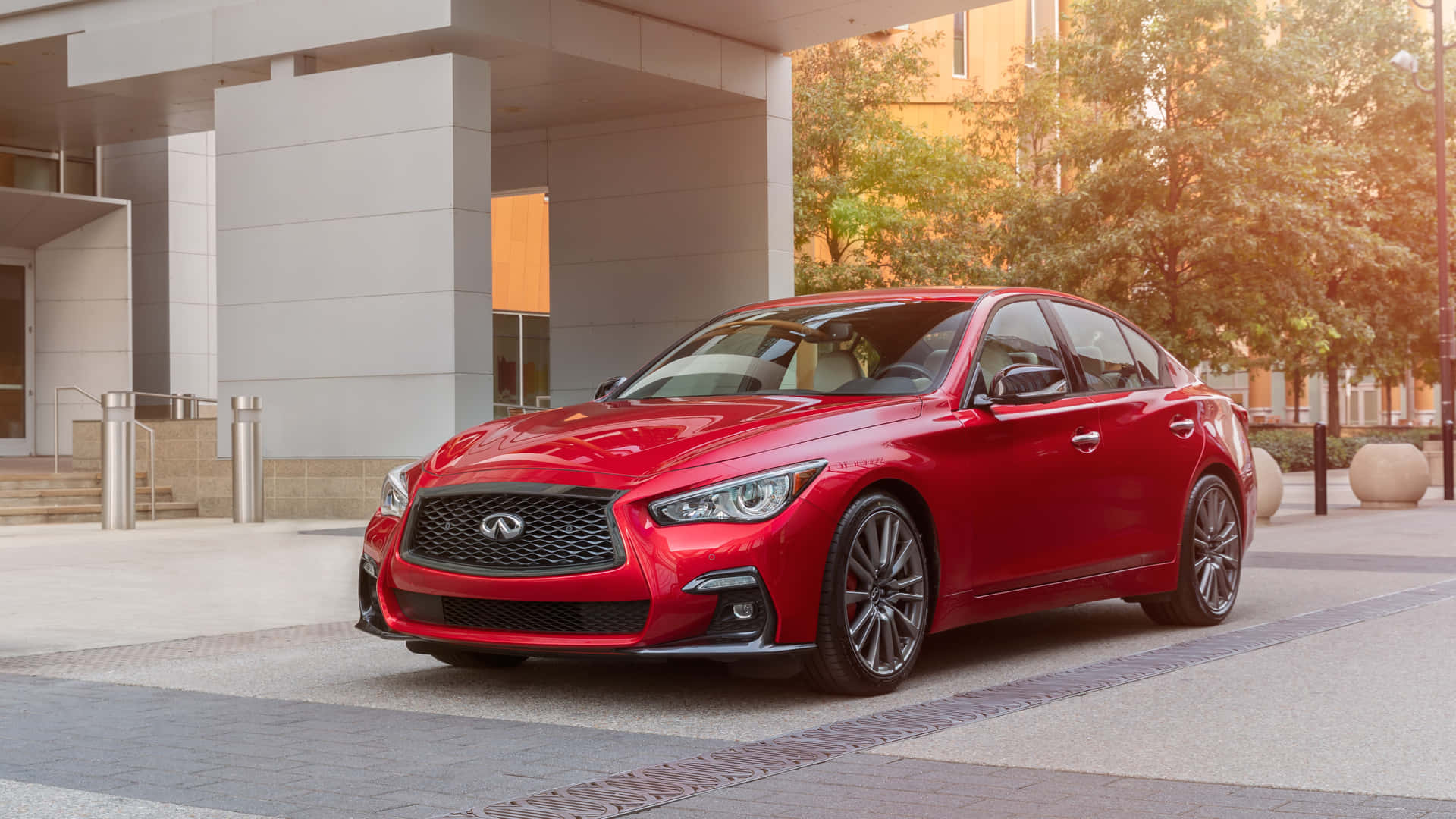 The Red 2019 Infiniti Q50 Is Parked In Front Of A Building Wallpaper