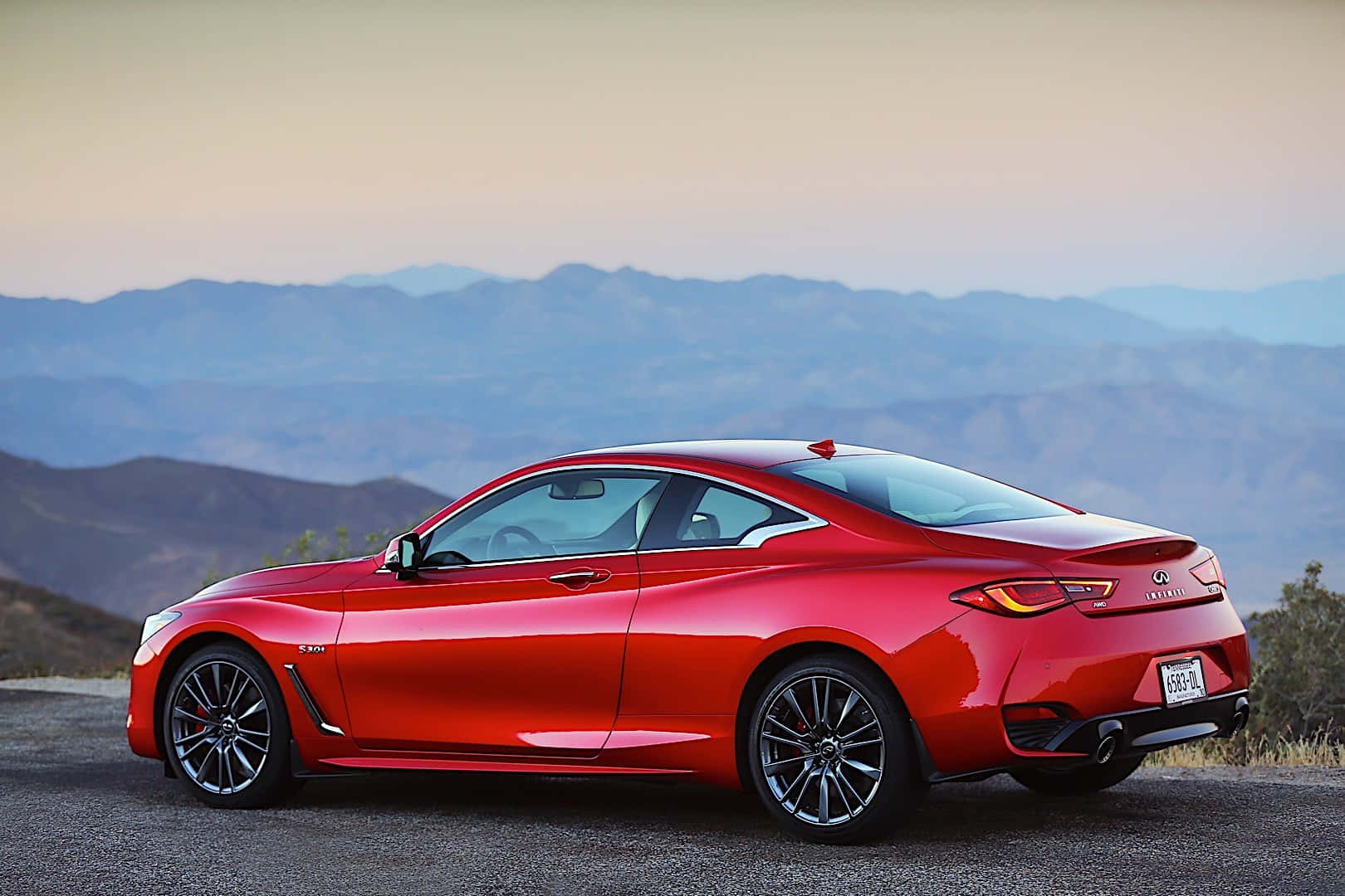 Caption: Elegant Infiniti Q60 Sports Car on the Road Wallpaper