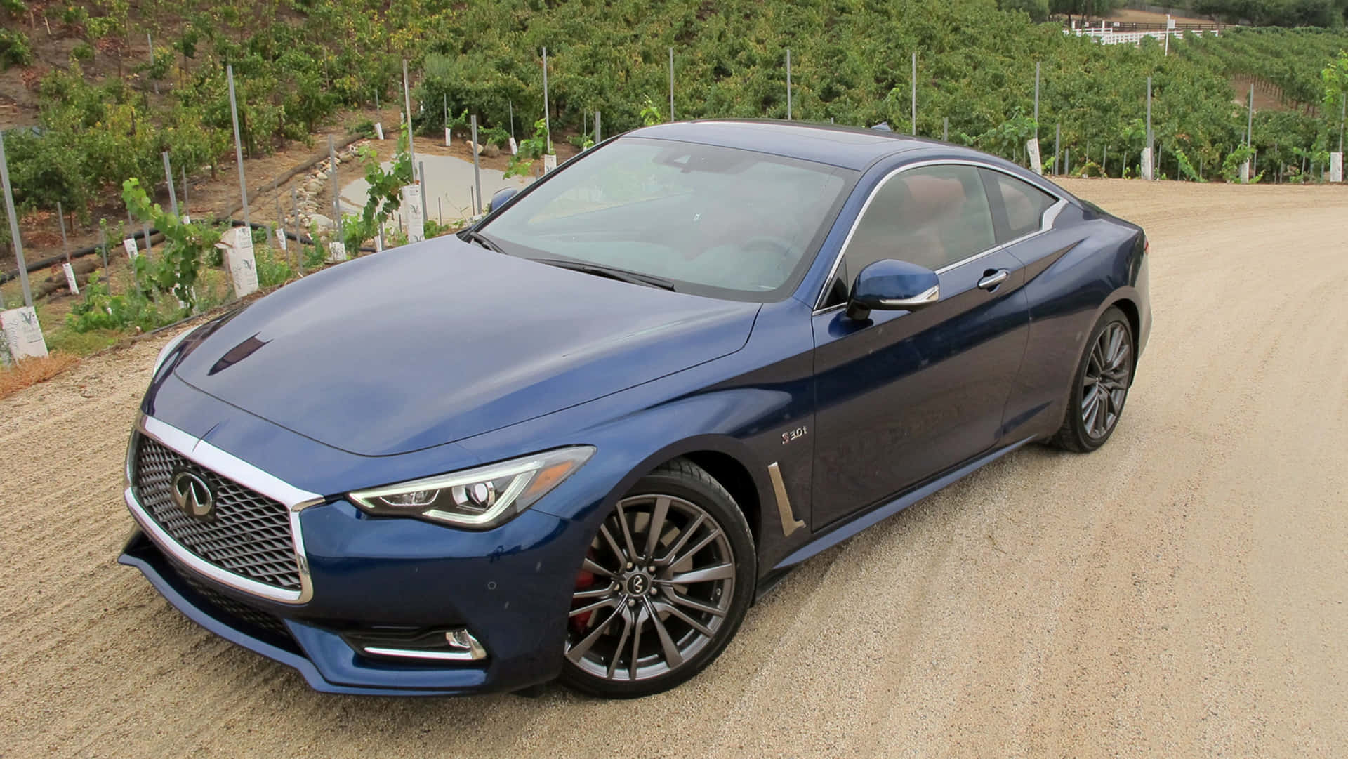 Sleek Infiniti Q60 Sports Coupe in Scenic Road Trip Wallpaper