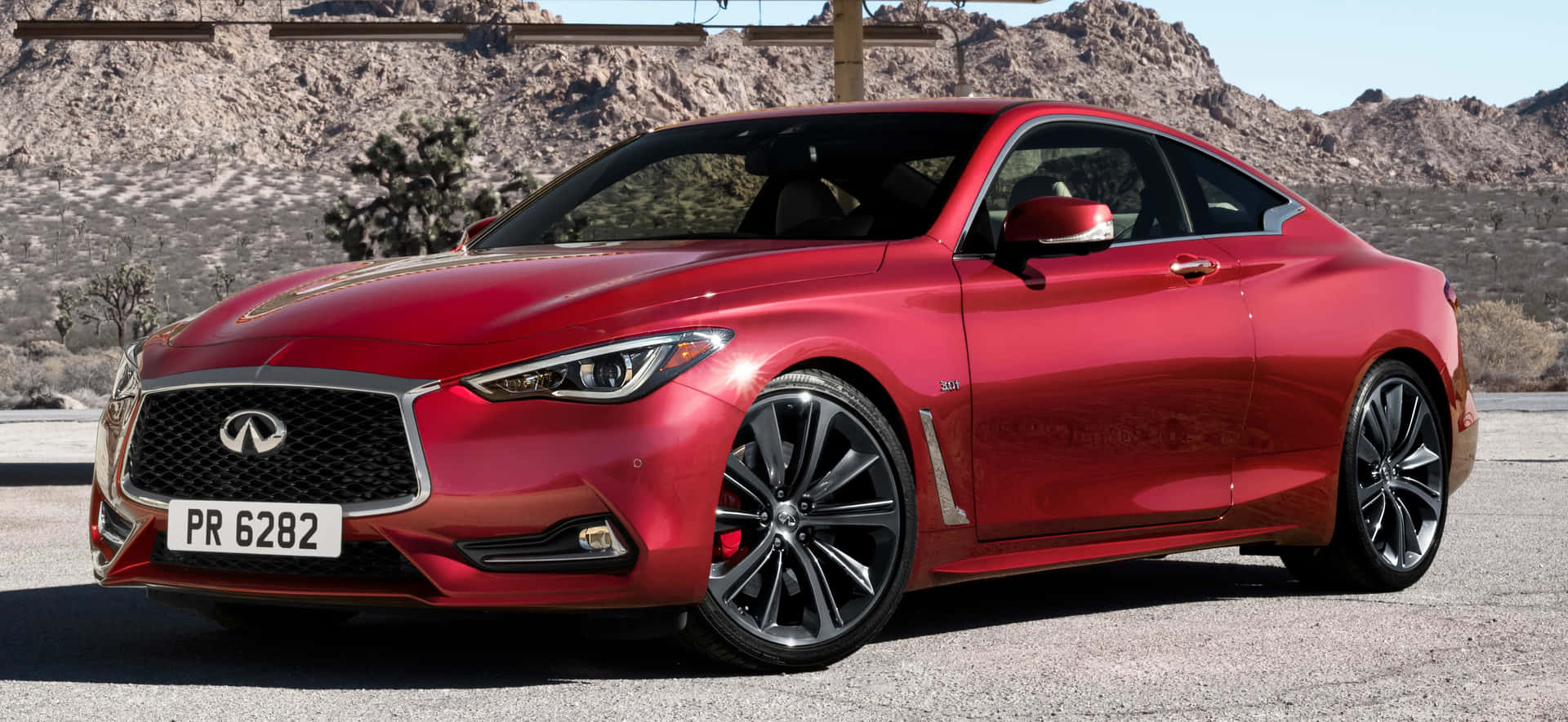 Sleek and Stylish Infiniti Q60 Sports Coupe in a Scenic Mountain Setting Wallpaper