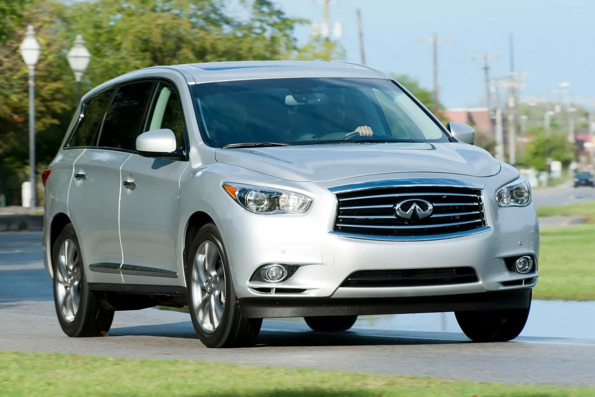 Luxurious Infiniti QX60 cruising on a scenic road Wallpaper