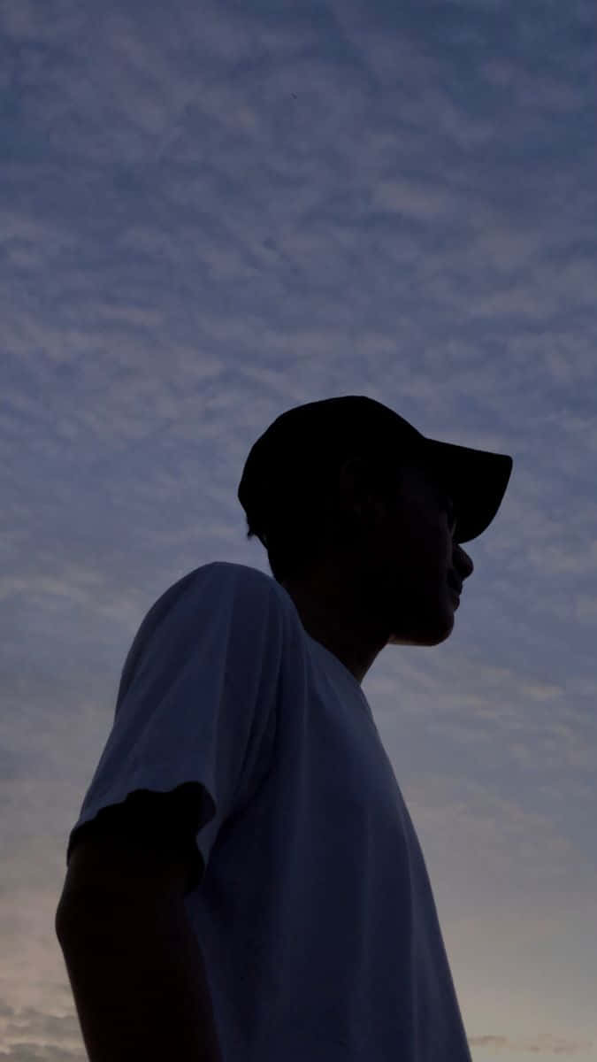A Man Is Silhouetted Against The Sky