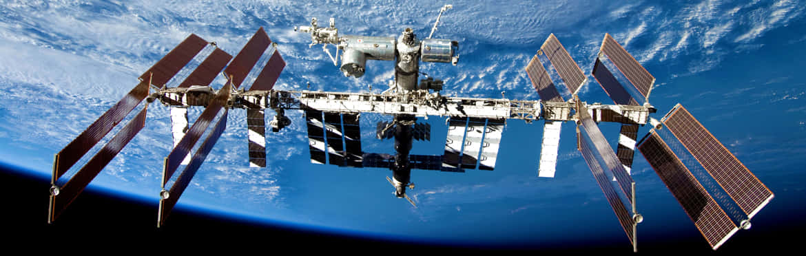 Caption: Stunning View of the International Space Station Orbiting Earth Wallpaper