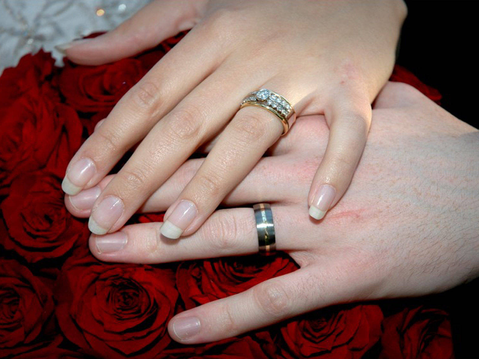 Intimate Holding Hands With Rings On Roses Wallpaper