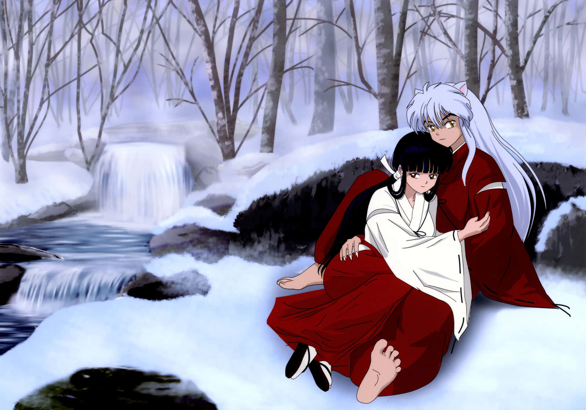 A Couple Sitting On A Snowy Hill In The Snow