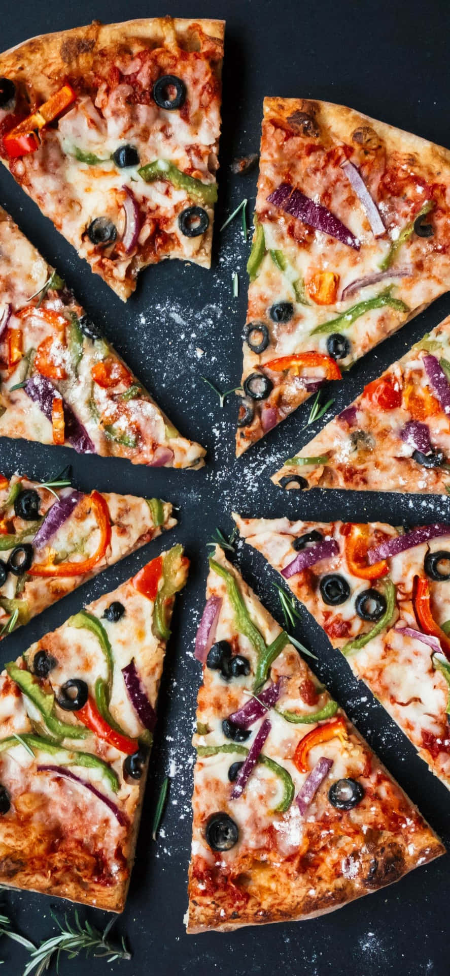 En pizza med grøntsager og oliven skæres i skiver Wallpaper