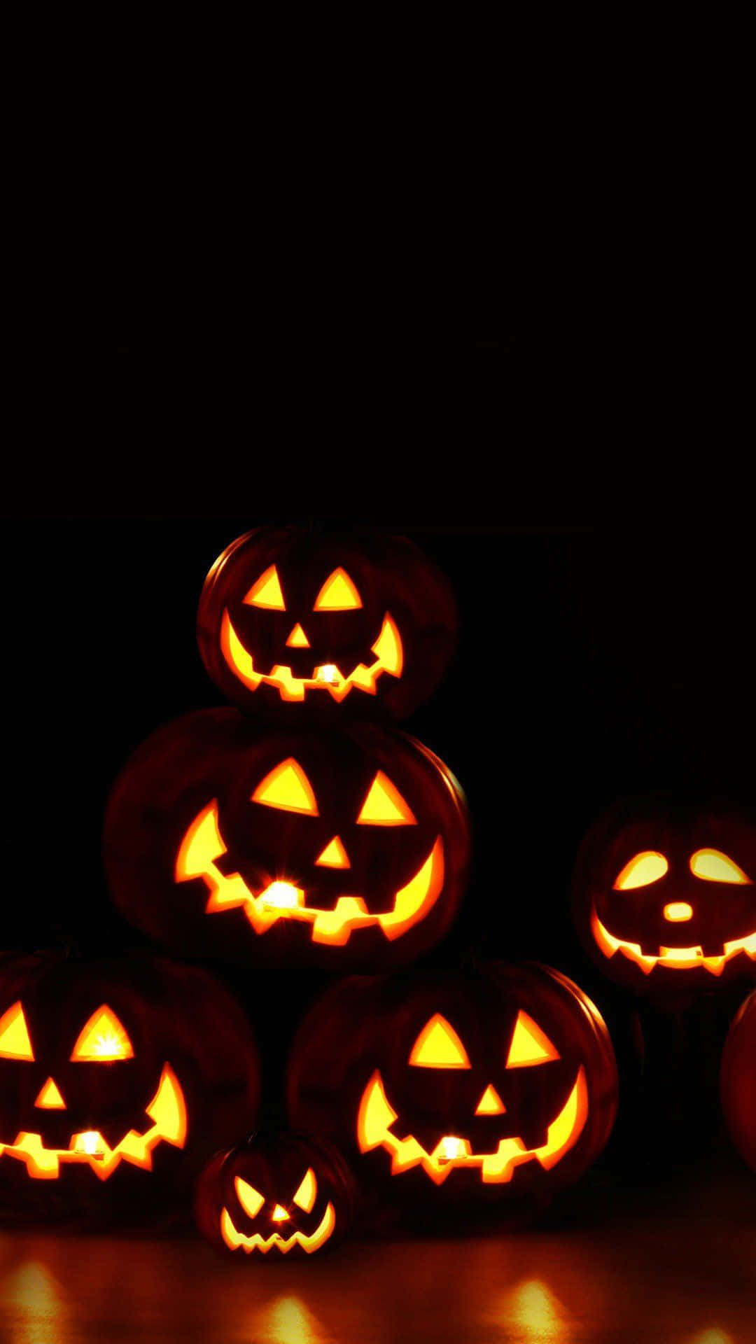 Läskigtutseende På Jack O'lanterns Iphone Halloween-bakgrund.