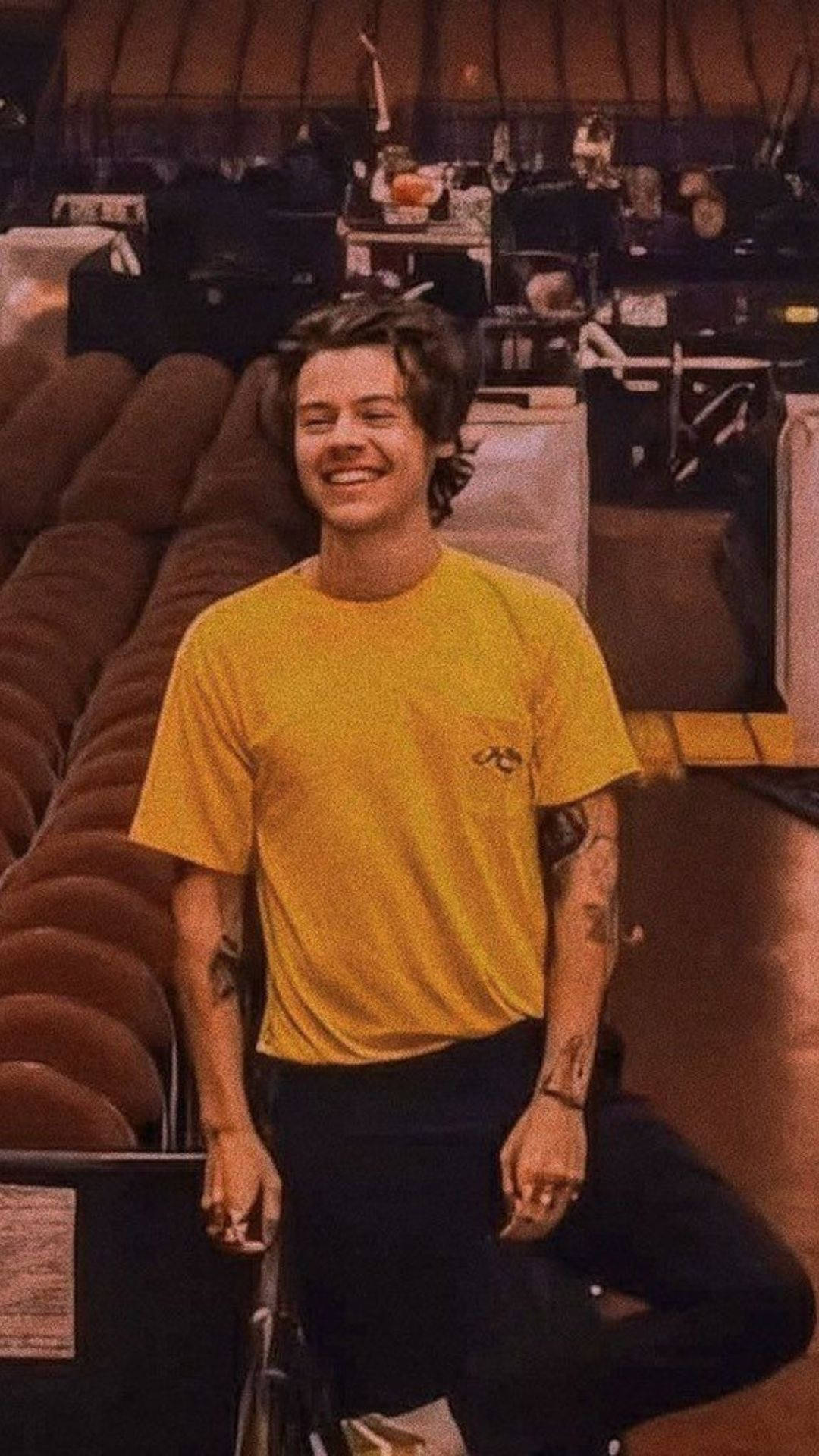 Iphonede Harry Styles Con Una Camiseta Amarilla Fondo de pantalla