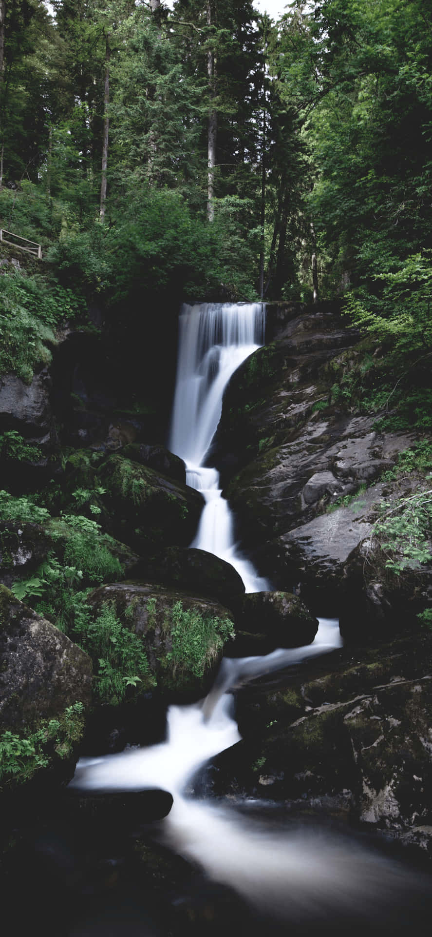 A spectacular waterfall cascading down a mountainside Wallpaper
