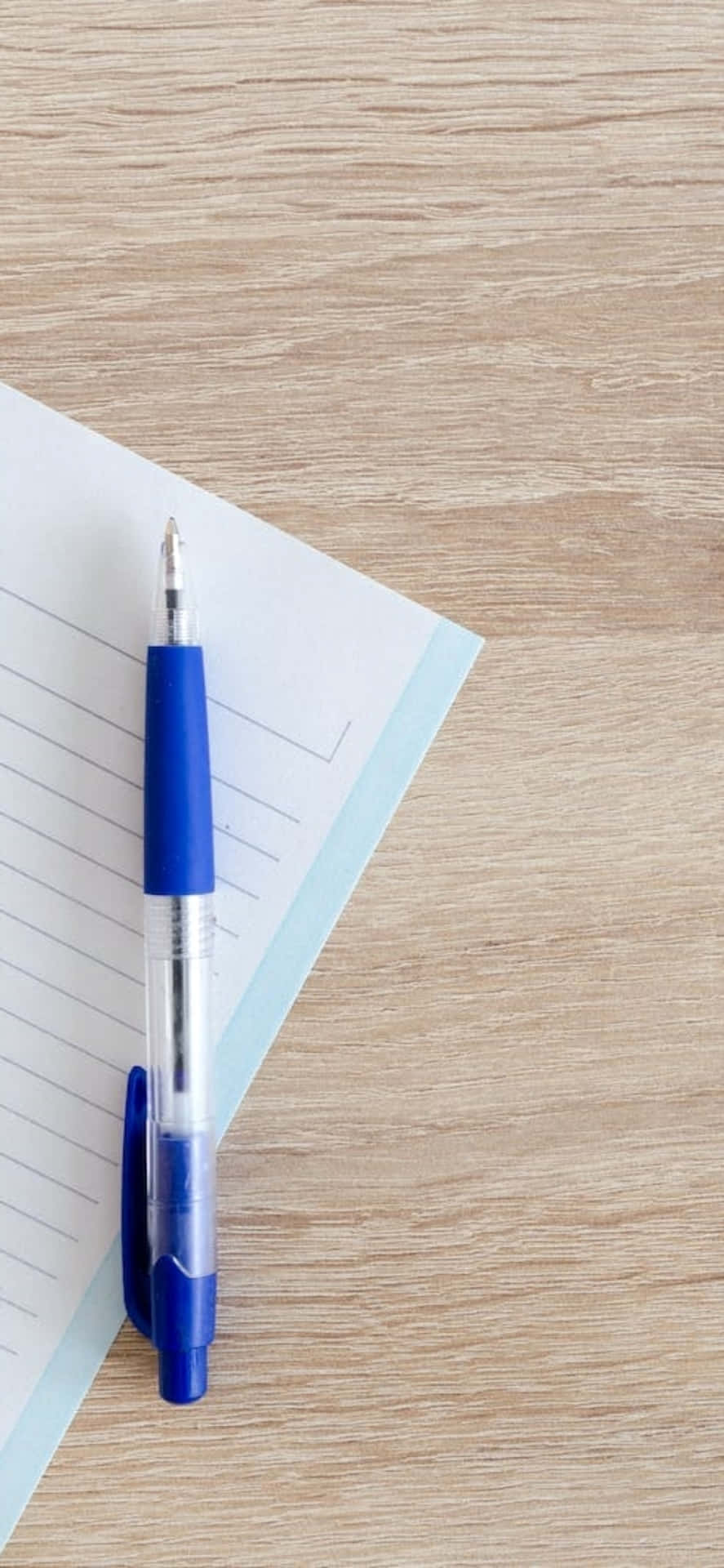 Fondode Escritorio Para El Iphone X Con Un Bolígrafo Azul Y Un Cuaderno.