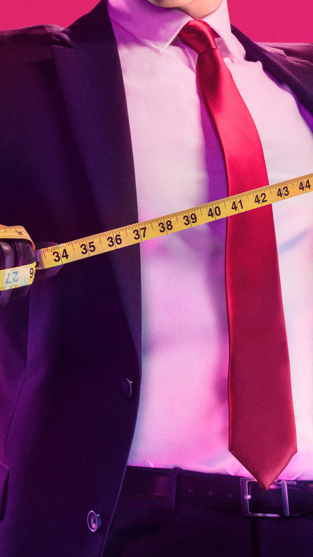 A Man In A Suit And Tie Holding A Measuring Tape