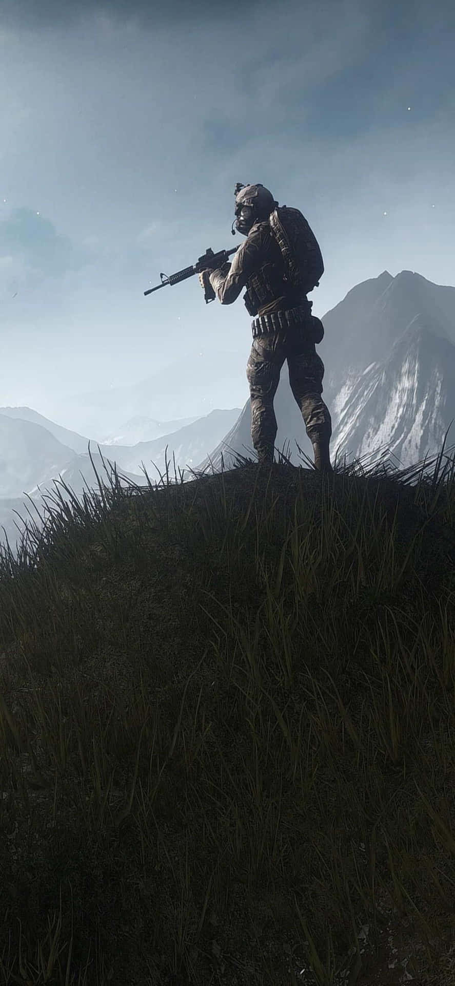 A Soldier Is Standing On A Hill With A Rifle