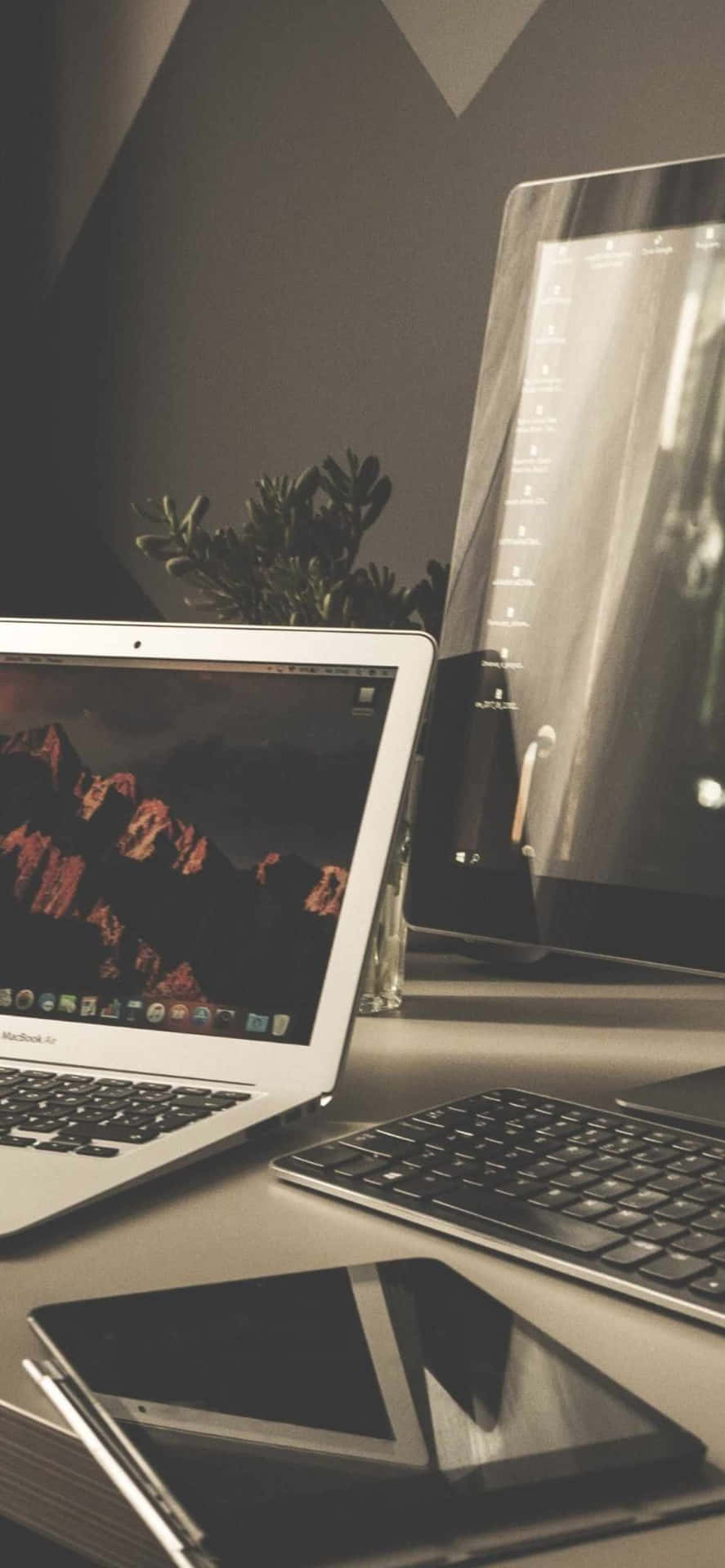 A Laptop, Tablet, And A Phone On A Desk