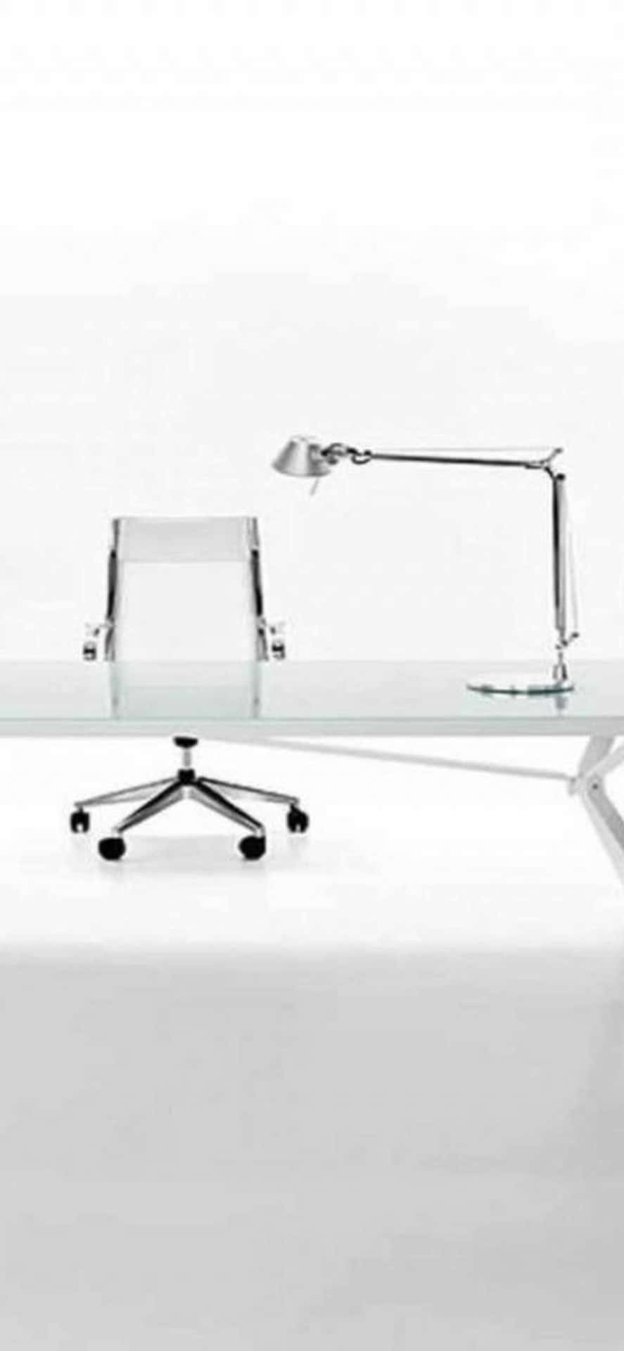 A Modern Glass Office Desk With A Chair And Lamp