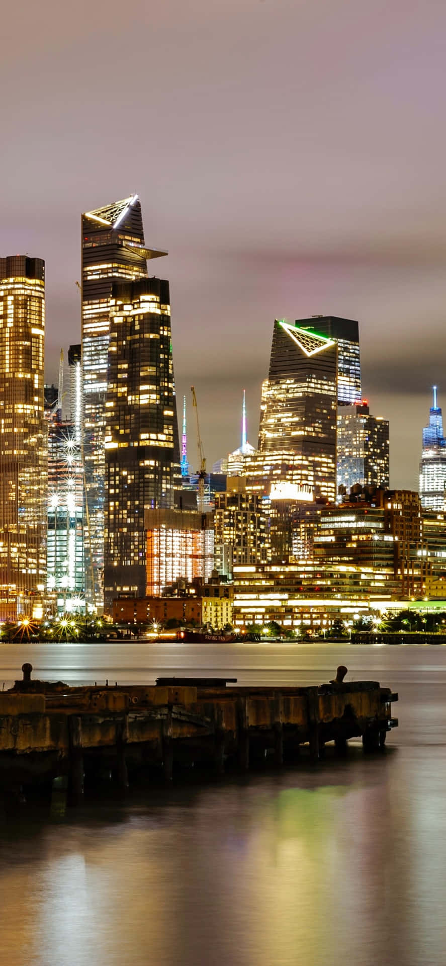 Diefreiheitsstatue, Die Über Die Nächtliche Skyline Von New York City Blickt.