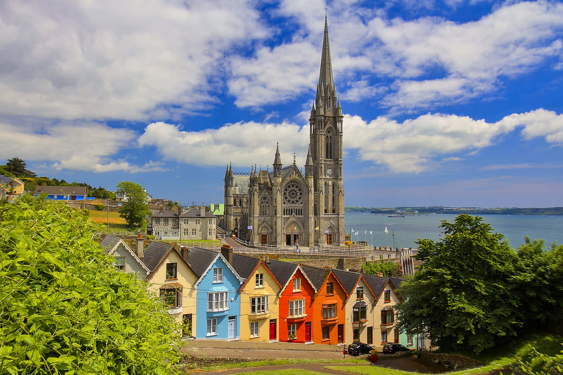 Kirke med farverige huse Irland Desktop Wallpaper Wallpaper