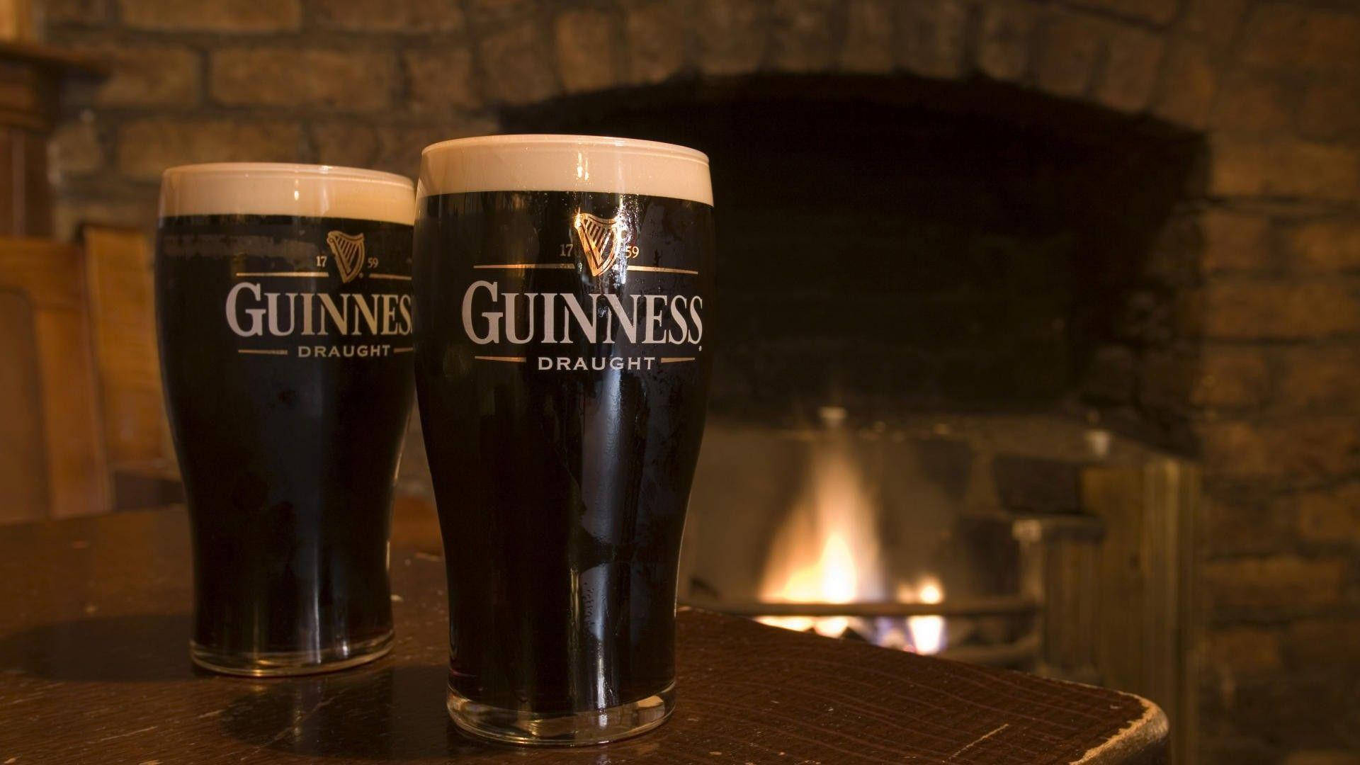 Irsk tør stout Guinness nær pejs Wallpaper