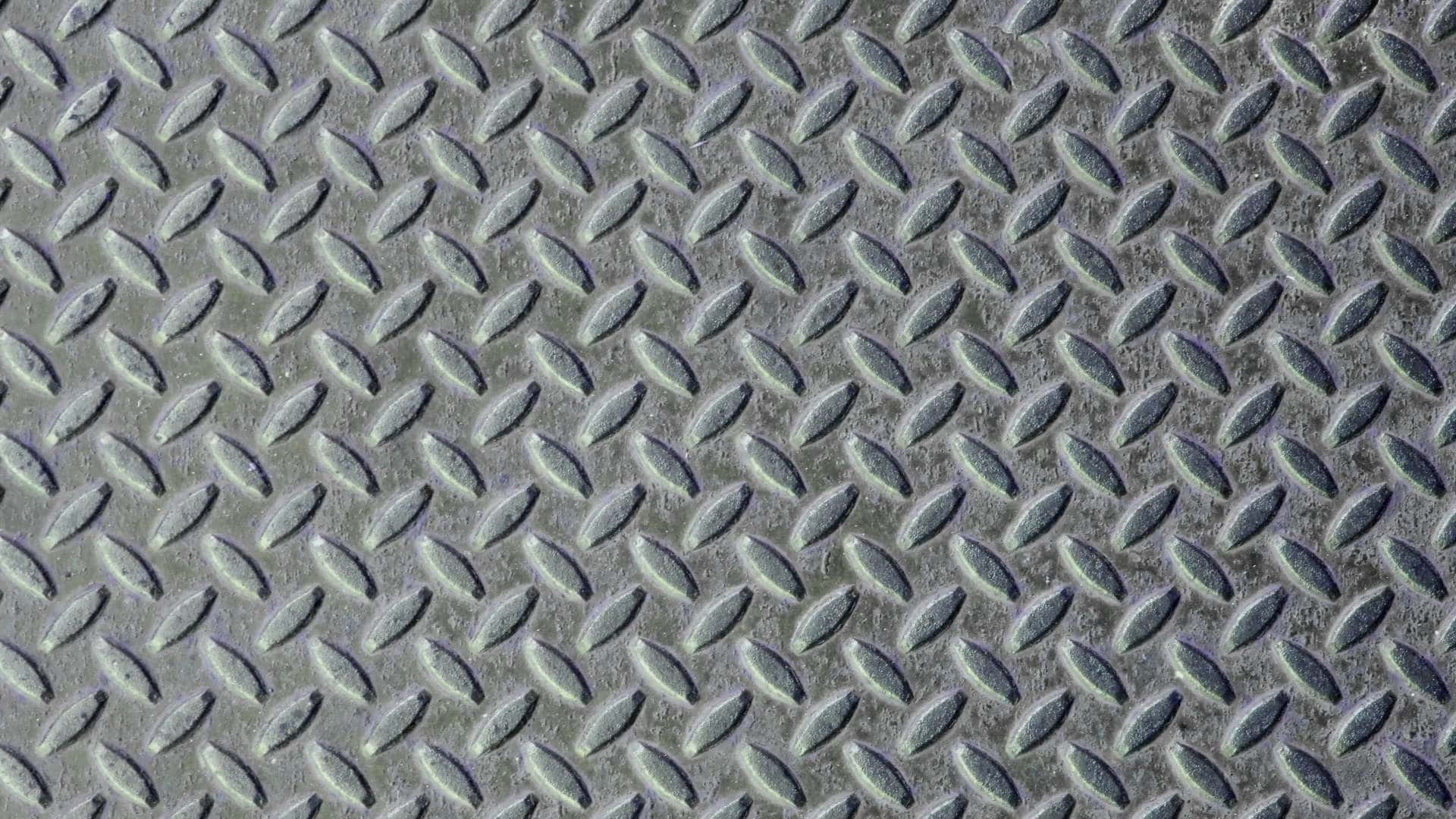 A Close Up Of A Metal Plate With Diamonds