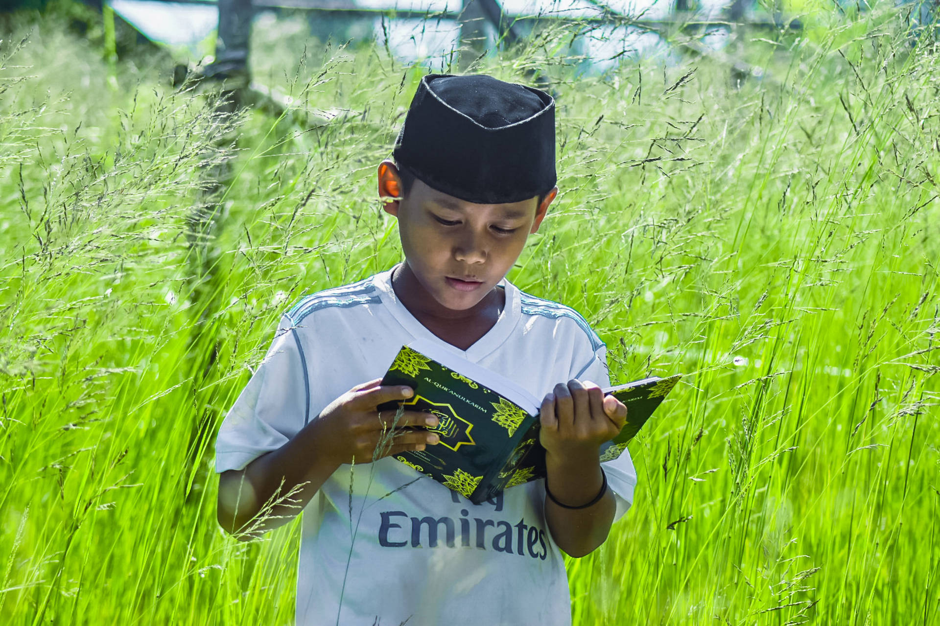 Islamic Boy Reading Quran Outdoors Background