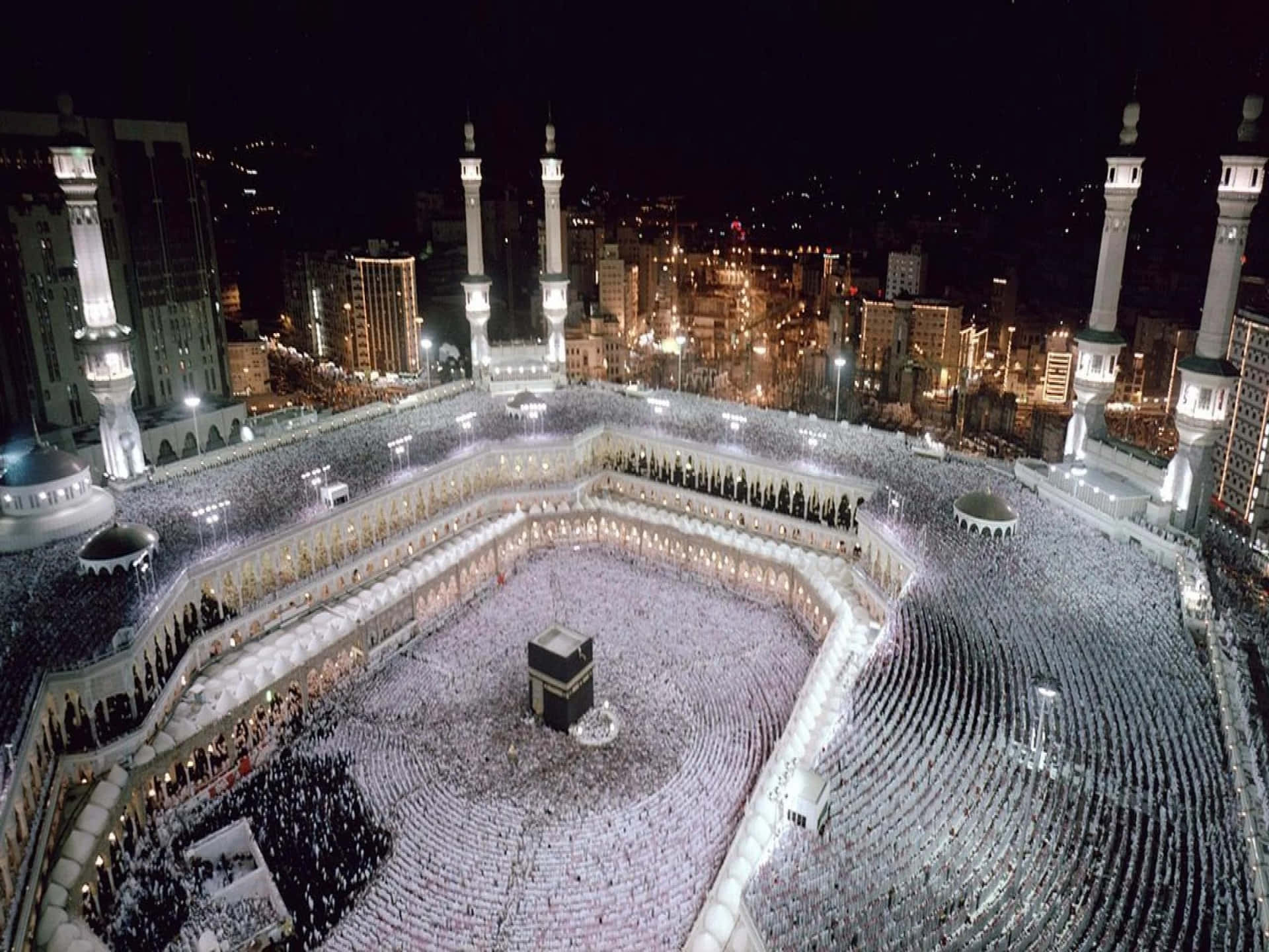 The Kaaba At Night With People Around It