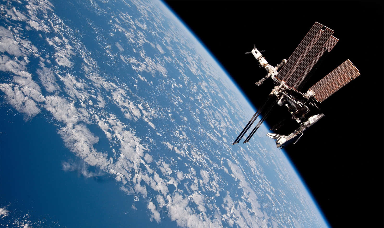 A breathtaking view of the International Space Station (ISS) orbiting above Earth Wallpaper