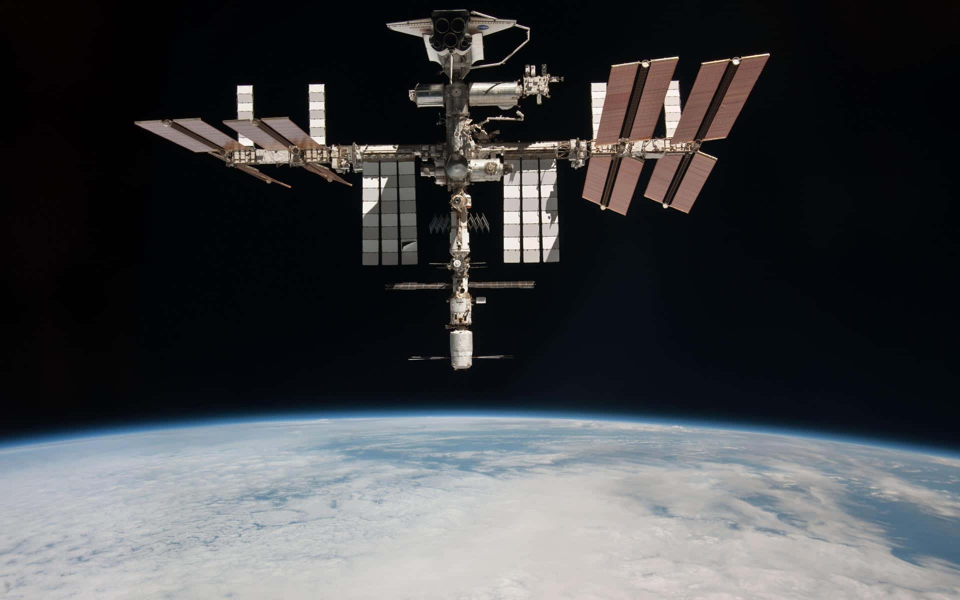 A breathtaking view of the International Space Station (ISS) orbiting Earth Wallpaper