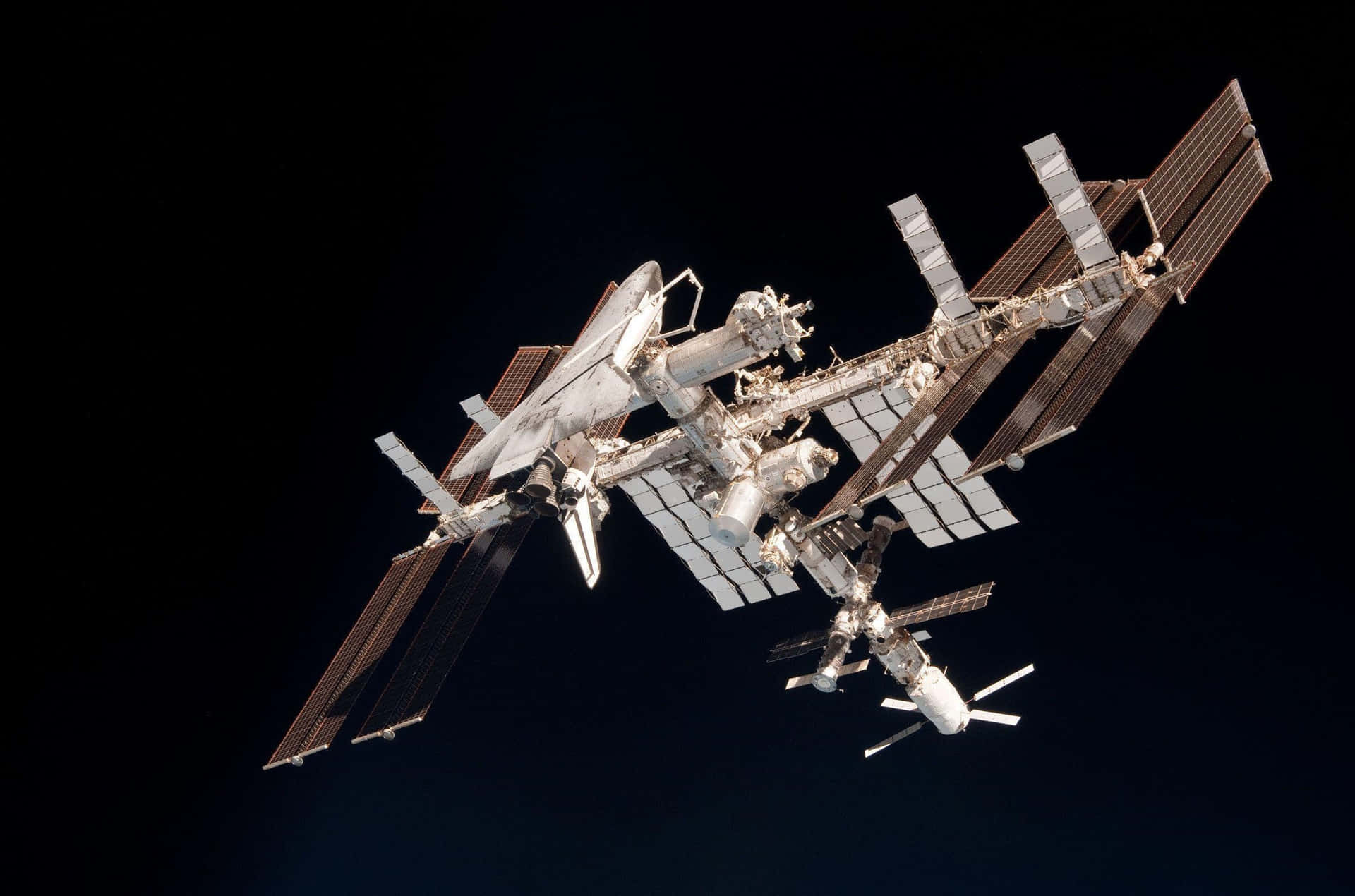Awe-inspiring view of the International Space Station against the backdrop of Earth Wallpaper