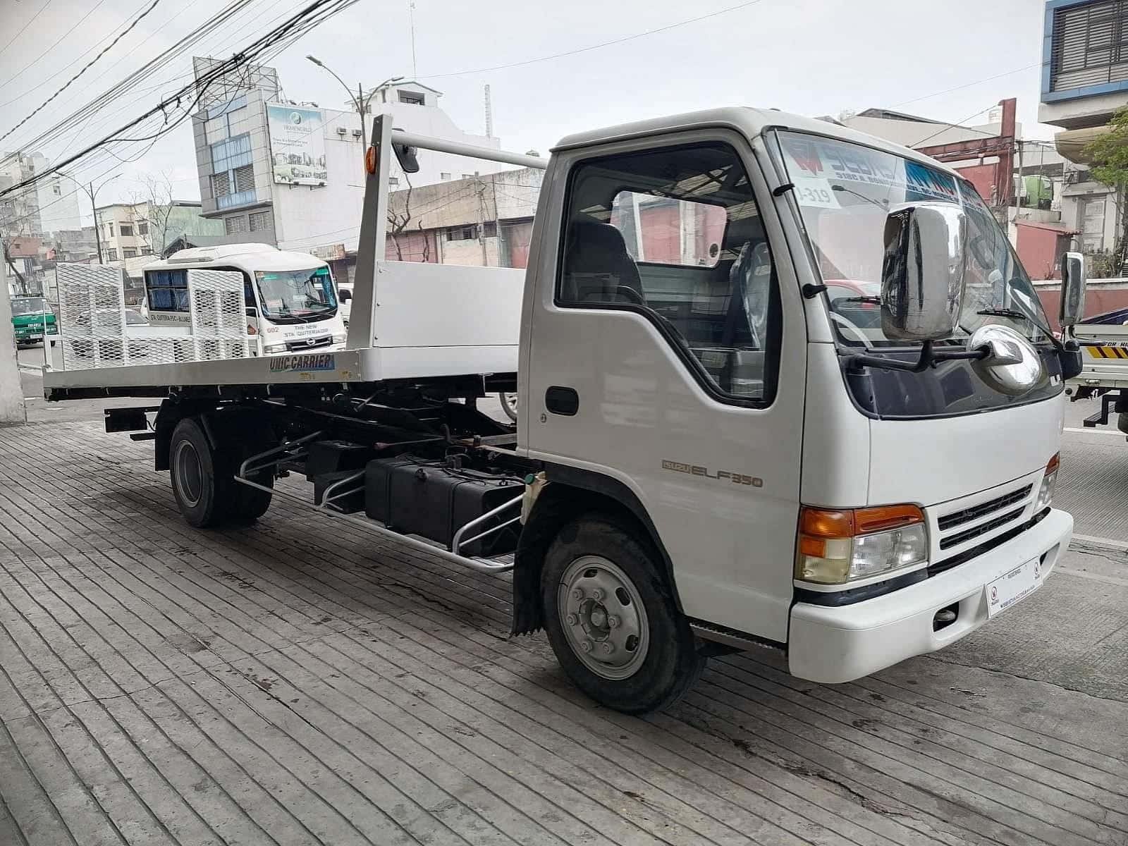 Isuzu Elf Vlakbed Truck Geparkeerd Op Straat Achtergrond