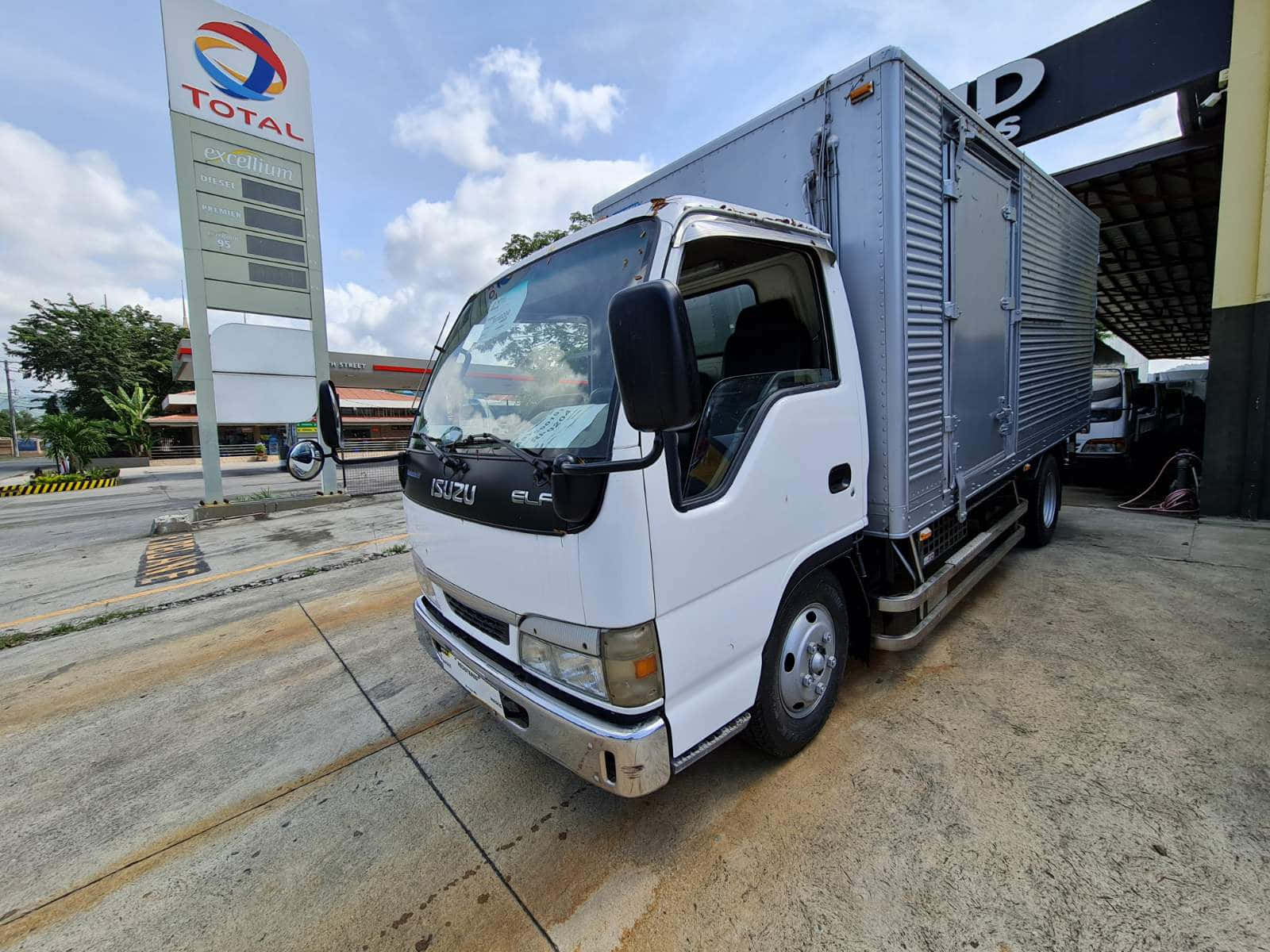 Isuzu Elf Truck Bij Tankstation Achtergrond