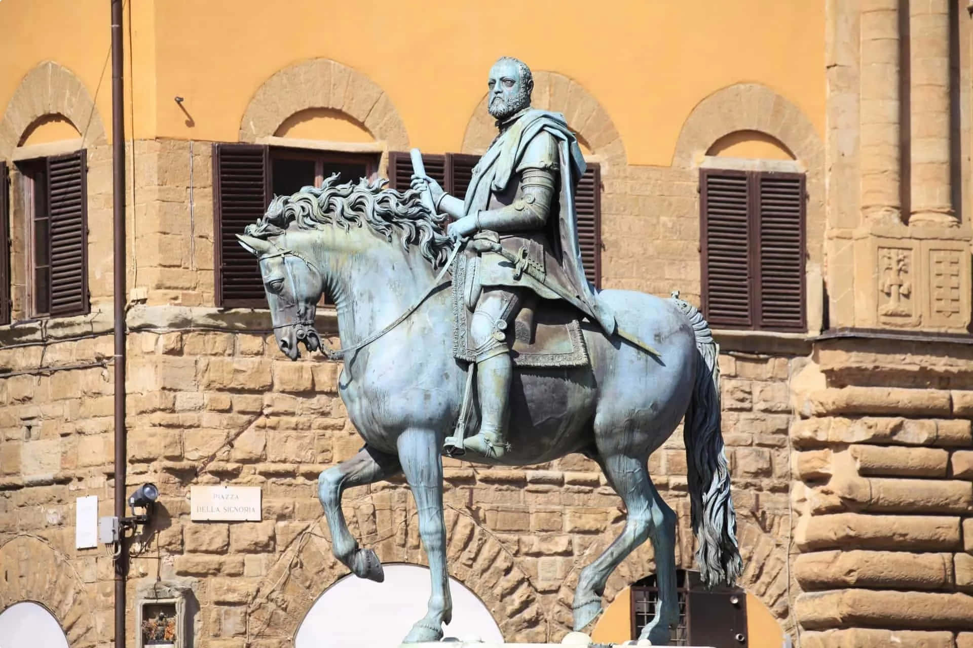 A Statue Of A Man On A Horse In Front Of A Building