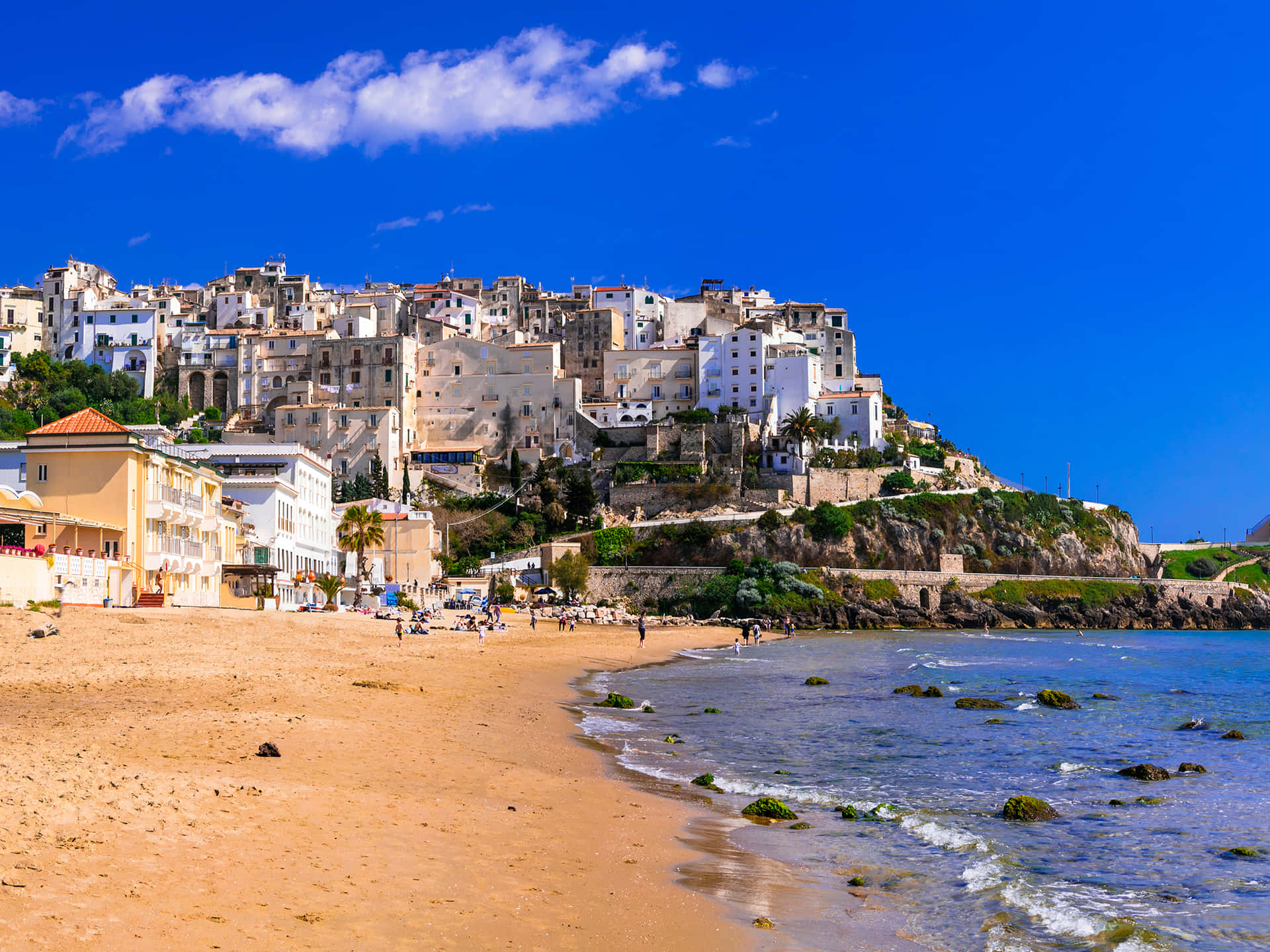 A breathtaking view of an idyllic Italian beach with crystal clear water and golden sand Wallpaper