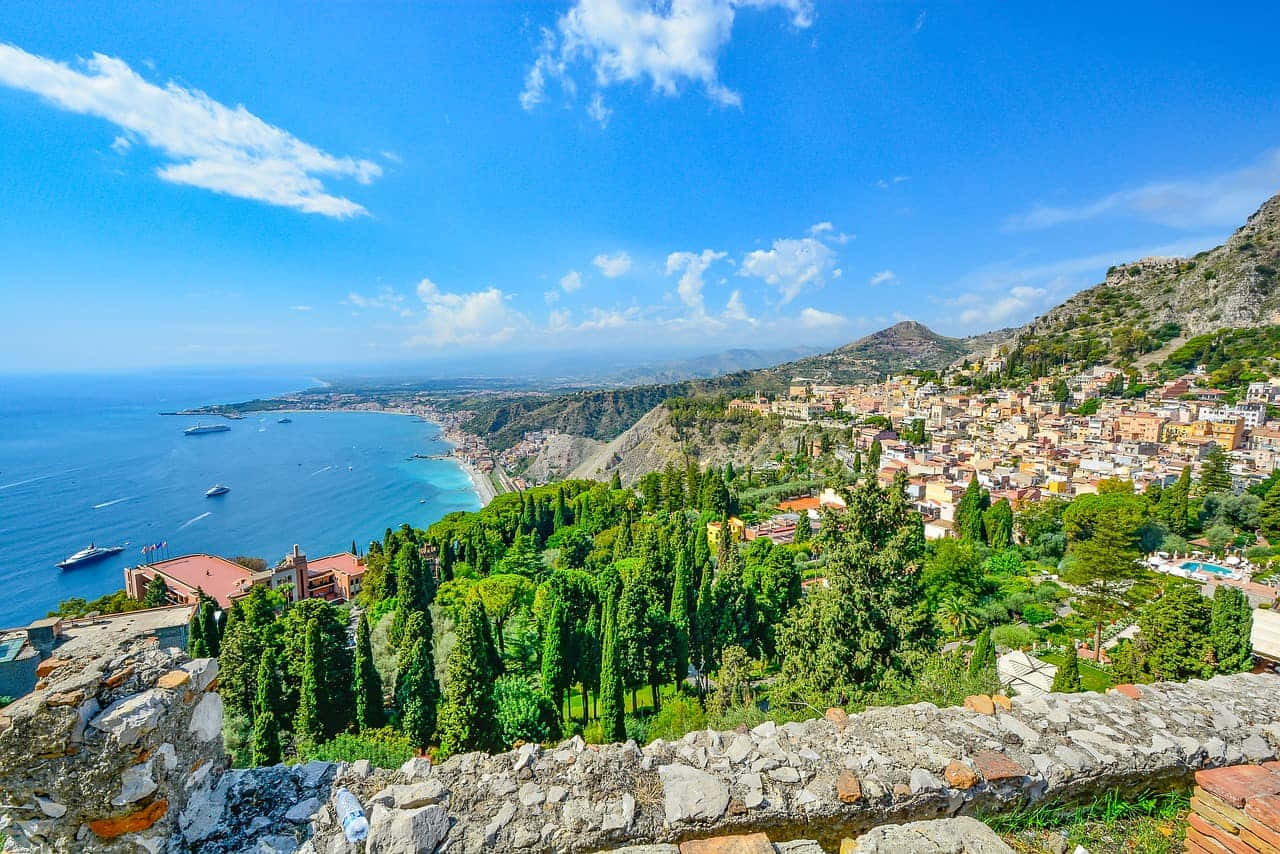 Picturesque Italian Island with Turquoise Waters and Colorful Village Wallpaper