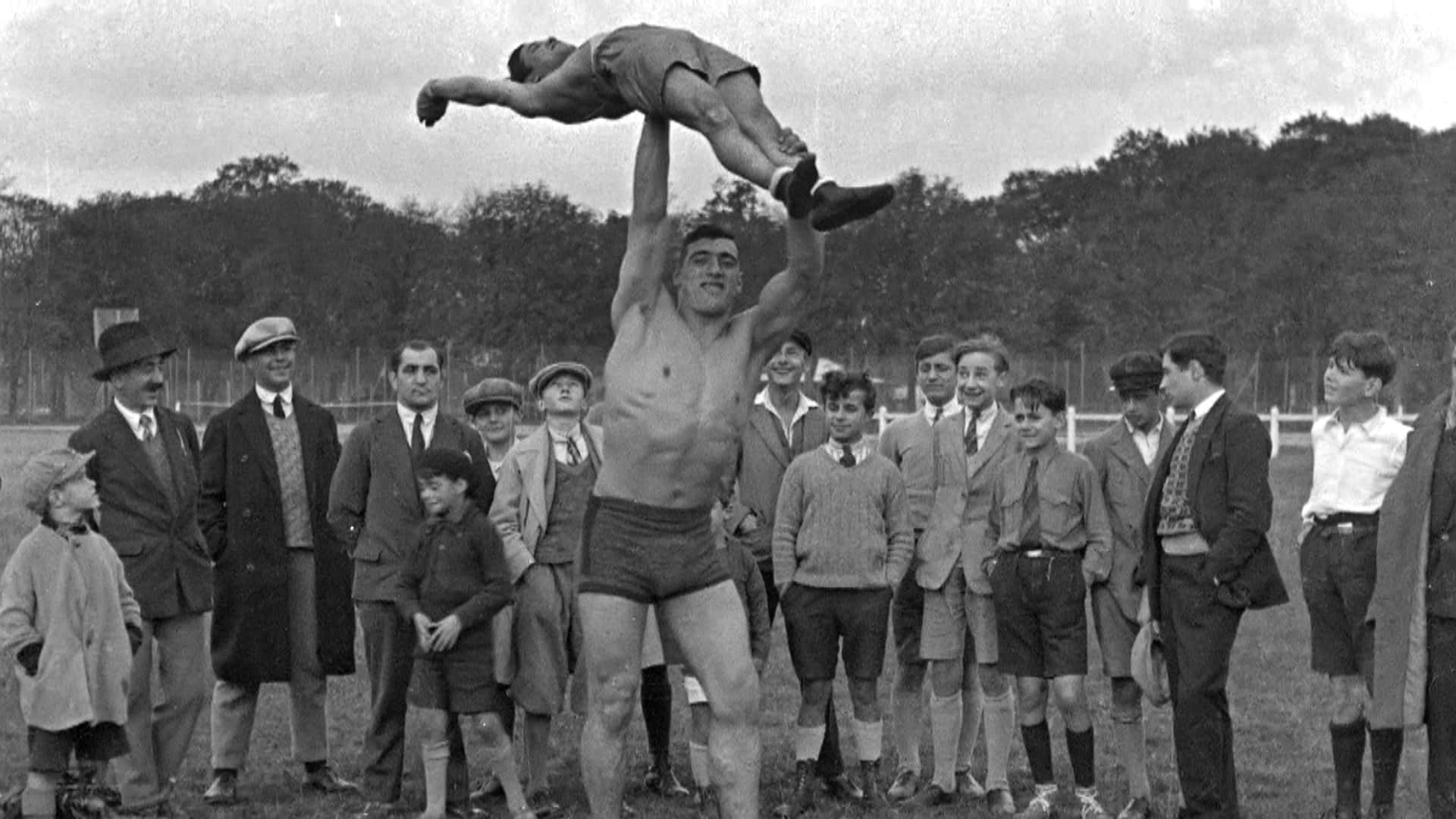 Italian Professional Boxer Primo Carnera Lifting A Man Picture