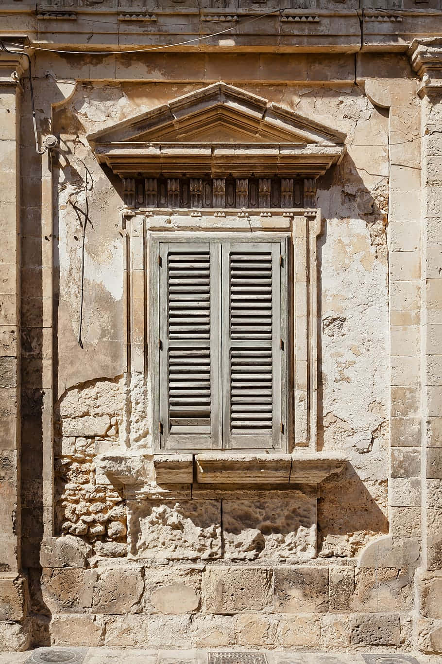 Et stenbygning med et vindue og efeu voksende på det. Wallpaper