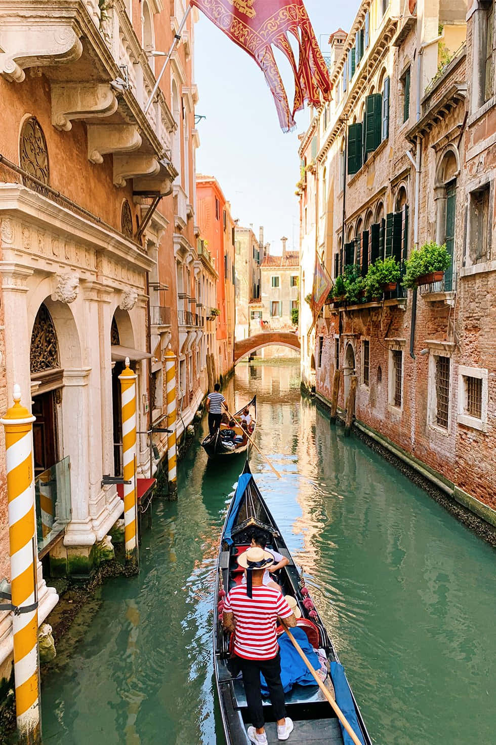 A Gondola Is Traveling Down A Narrow Canal