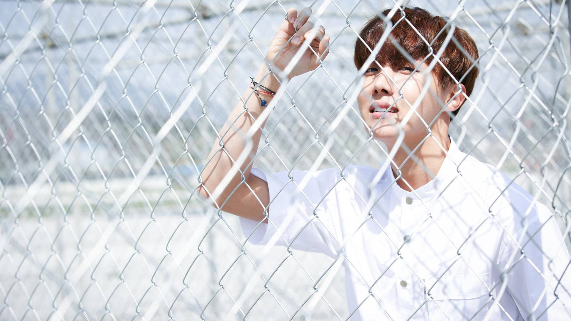 J-Hope Holding On A Fence Wallpaper
