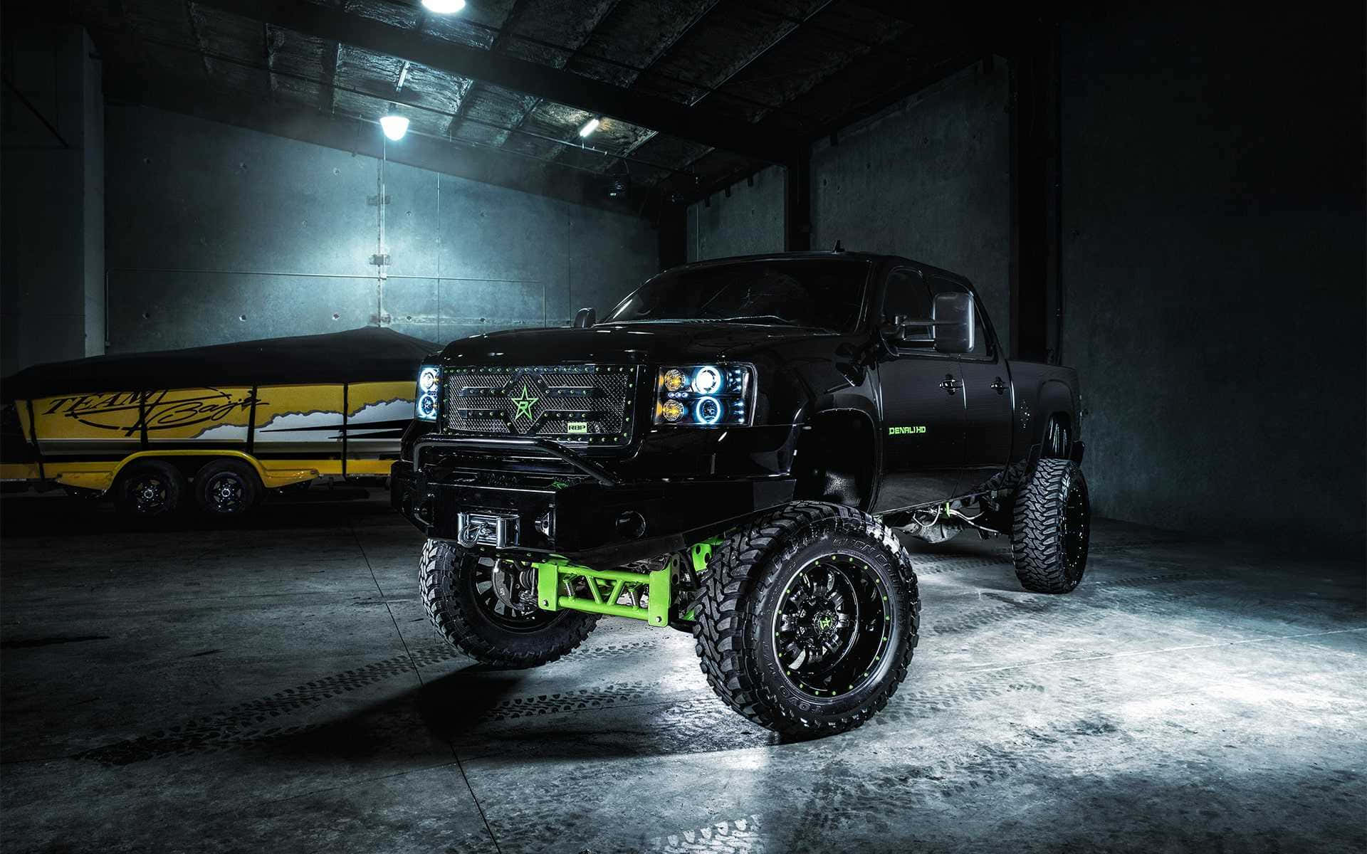 A Black Truck With Green Lights In A Garage Wallpaper