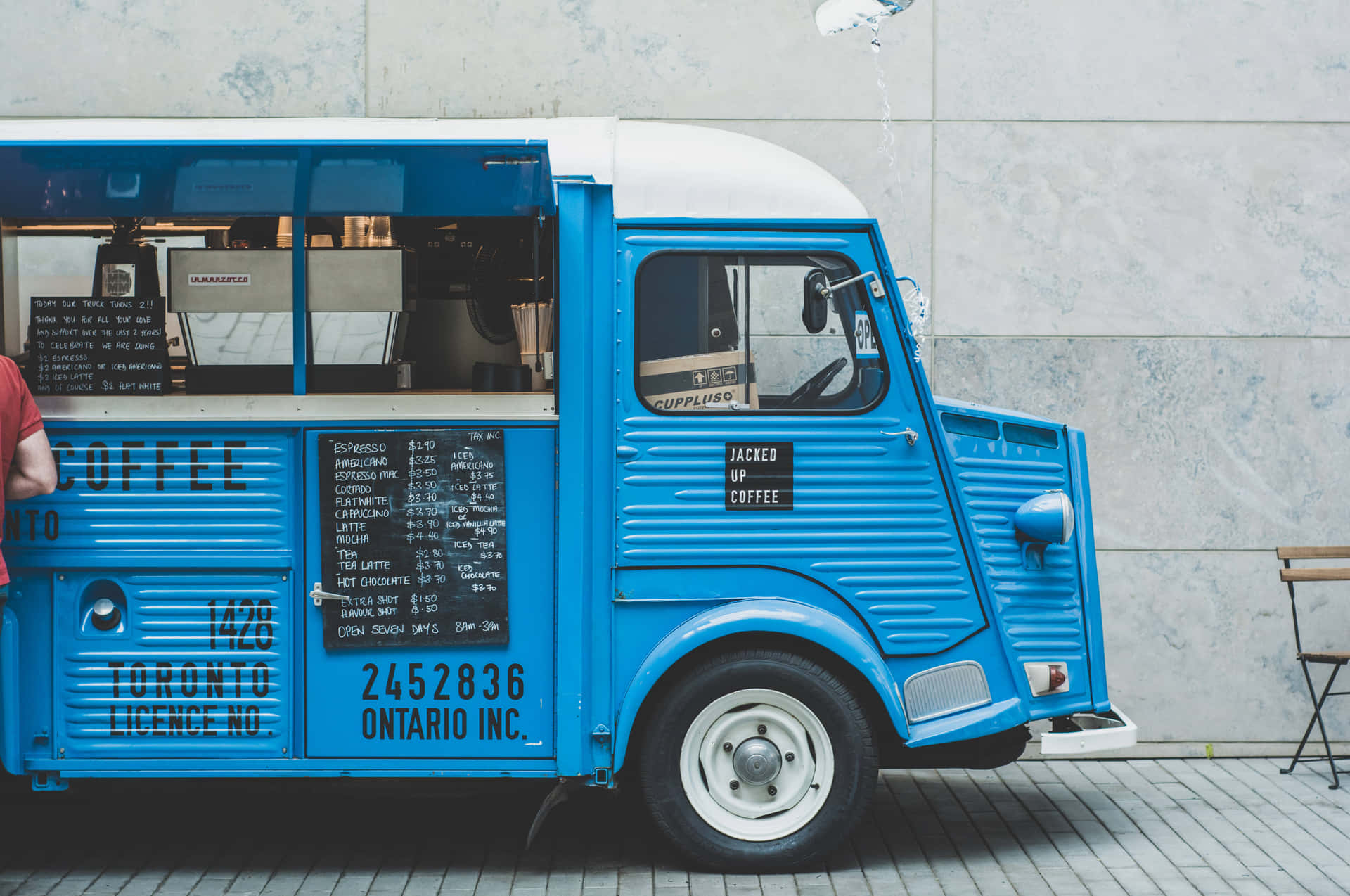 A Blue Food Truck With A Man Standing Next To It Wallpaper