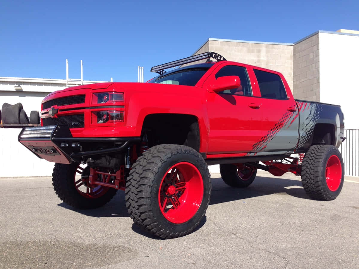 Jacked Up Trucks With Vibrant Red Paint Wallpaper