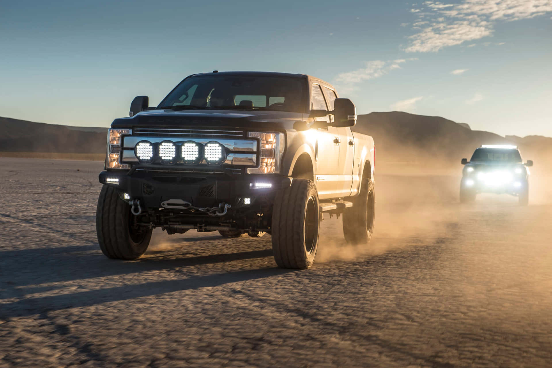 Jacked Up Trucks With Lit-up Headlamps Wallpaper