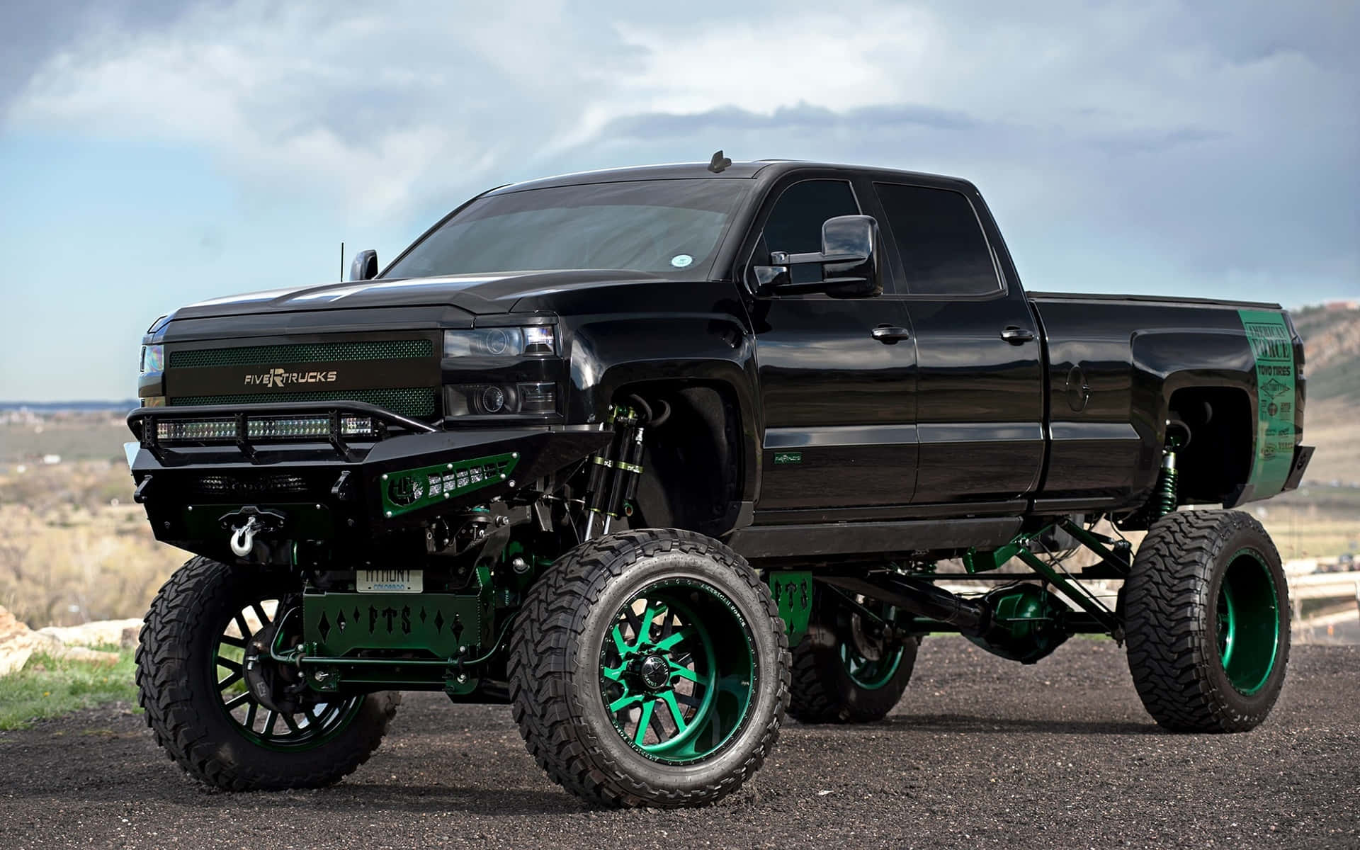 A Black Truck With Green Wheels On It Wallpaper