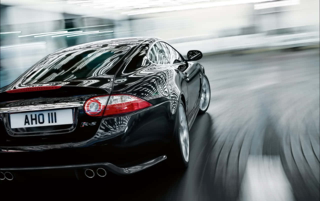 Sleek Jaguar XKR sports car on the road Wallpaper