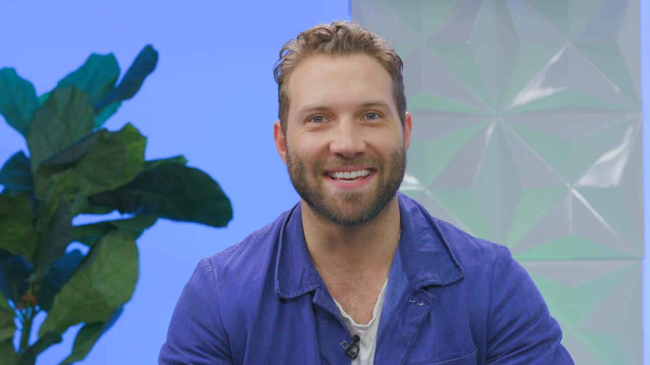 Jai Courtney Smilingin Blue Shirt Wallpaper