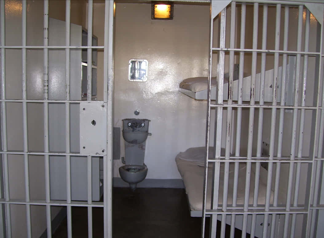 A White Toilet In A Prison Cell