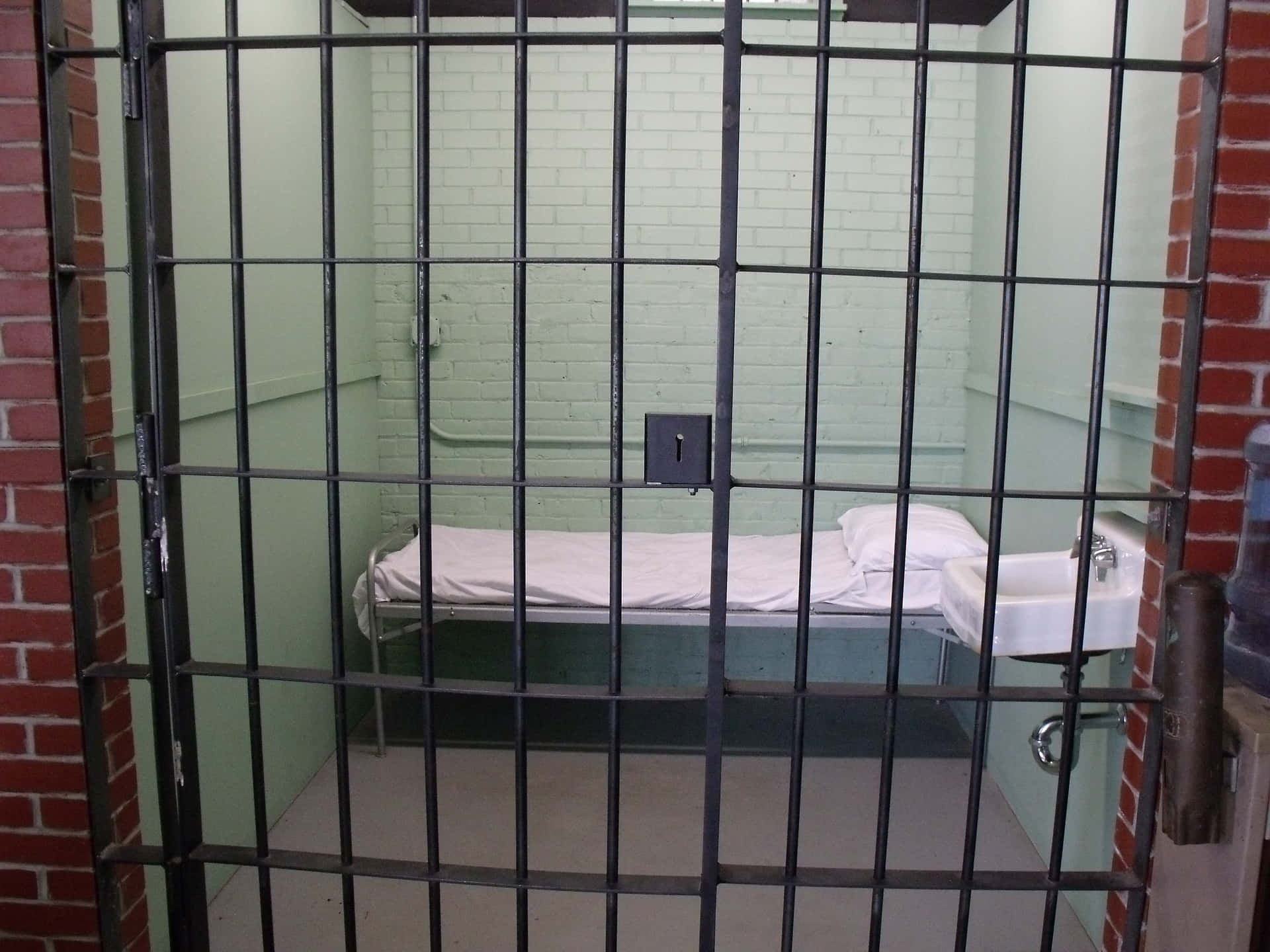 A Prison Cell With A Bed