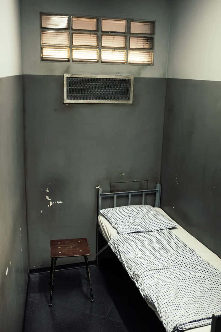 Et seng i et celle med et vindue